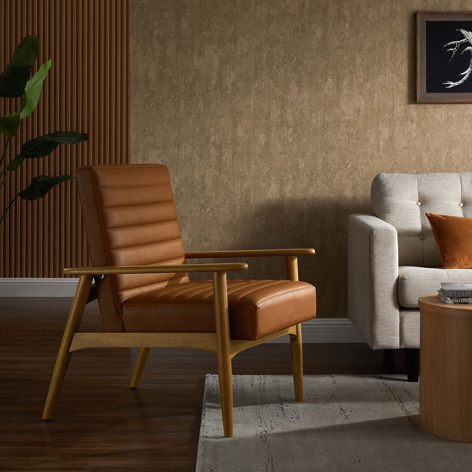 Warm tan vegan leather and oak-toned wood anchor a cozy living space with inviting, mid-century lounge comfort. || EEI-6779-FRO-TAN || front_angle_room