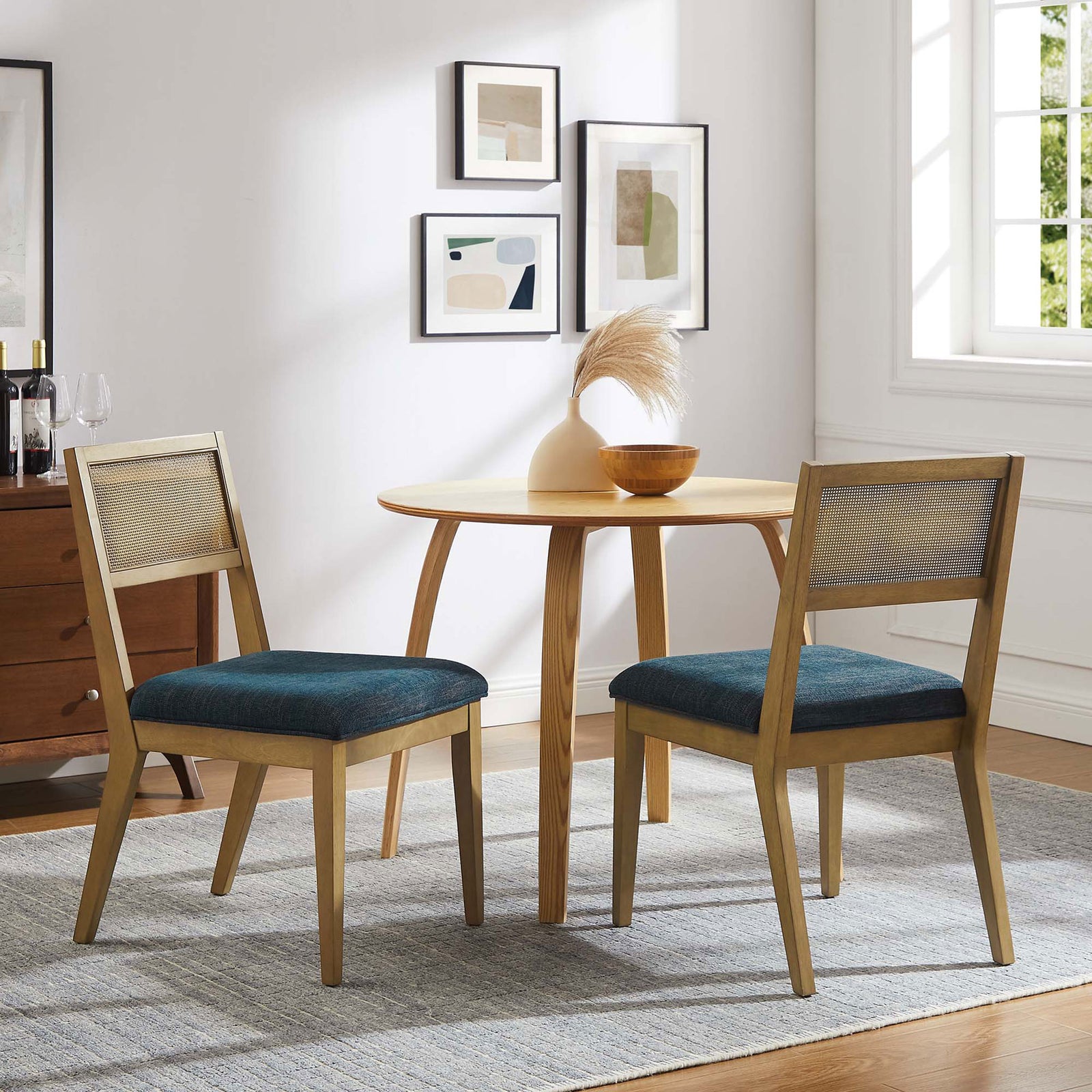 Pair of Nimba dining chairs around a round table, blending cane backs and blue seats into a cozy dining space || EEI-6781-FRO-HEA || front_angle_multi_room