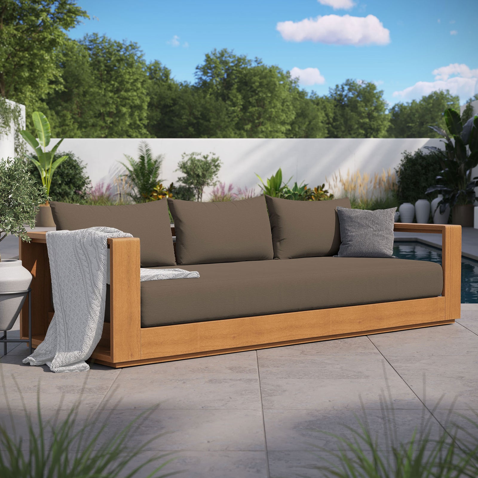 Tahoe outdoor sofa with cocoa cushions styled with pillows beside a modern poolside garden. || EEI-6784-NAT-COA || front_angle_room
