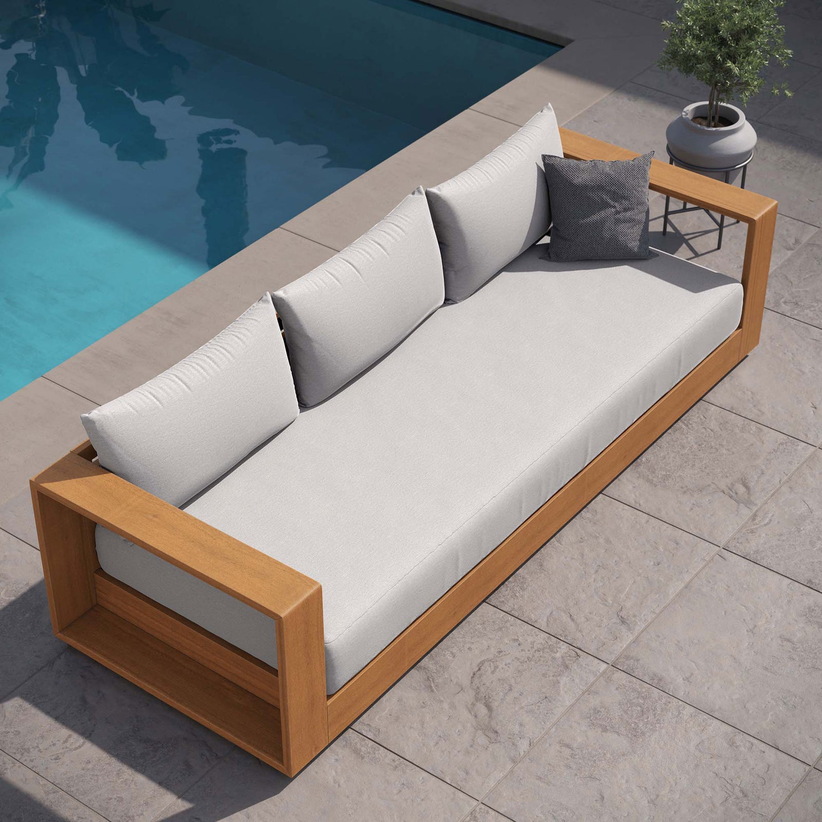 Tahoe outdoor sofa with light gray cushions arranged poolside on stone tile for airy lounging. || EEI-6784-NAT-LGR || front_angle_room