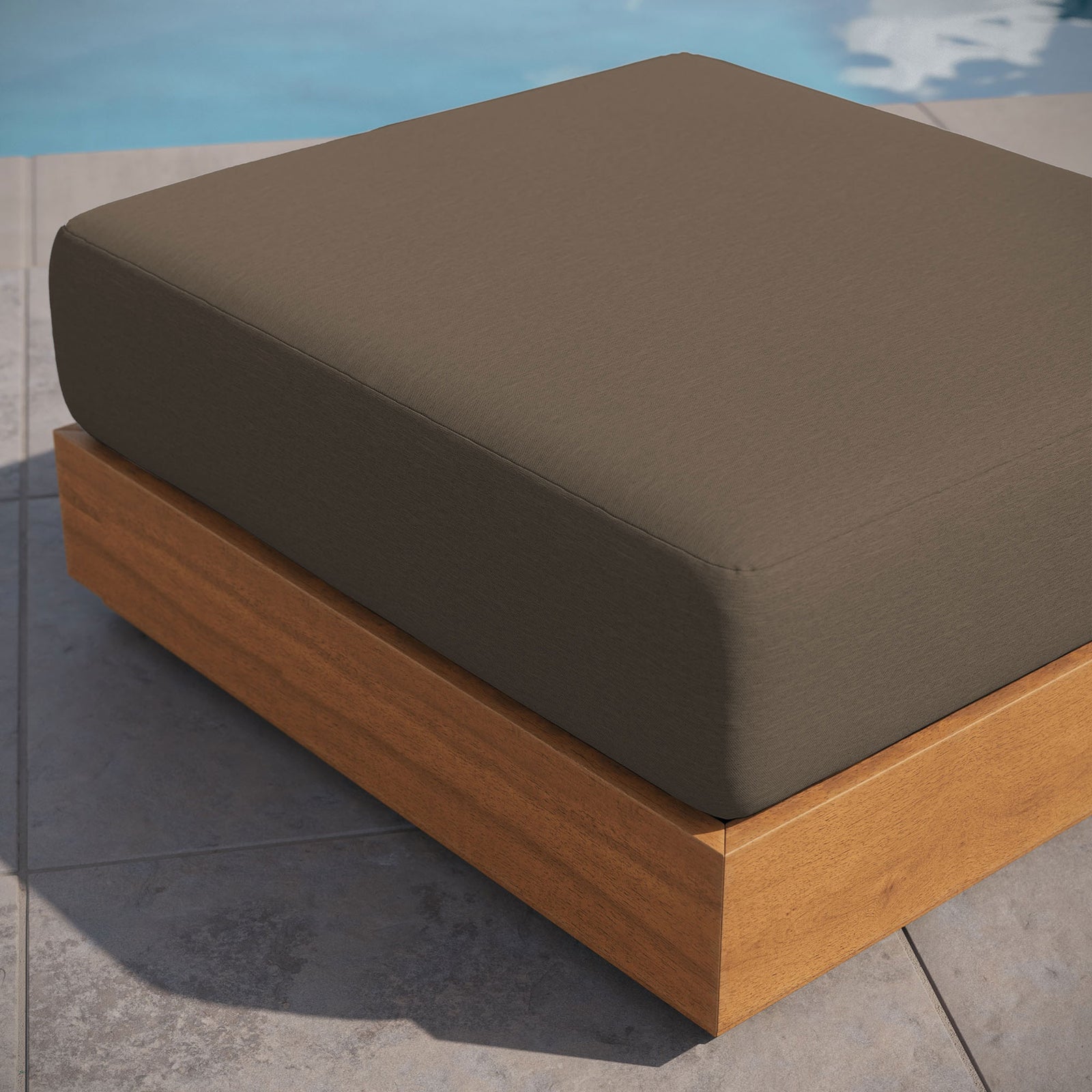 Tahoe acacia wood ottoman with cocoa cushion styled beside a serene poolside patio || EEI-6785-NAT-COA || front_angle_room