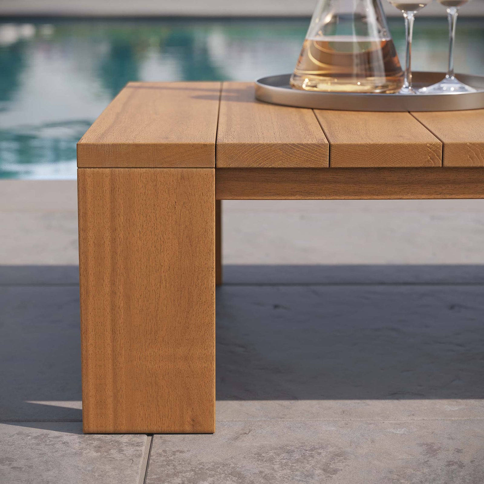 Detail of the acacia table leg and slatted top styled beside a poolside patio || EEI-6786-NAT || leg_room