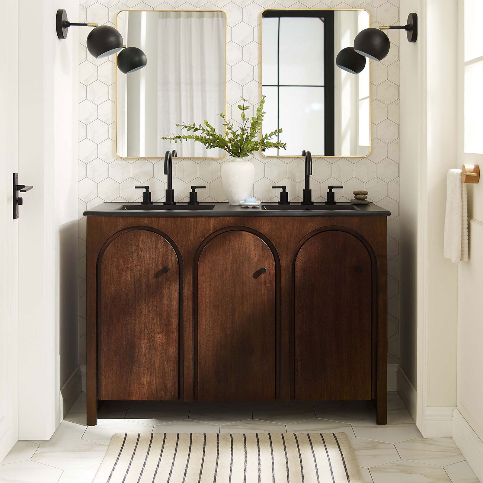 Warm walnut cabinet with arched doors and black double sinks anchors a modern, light-filled bathroom || EEI-6793-WAL-BLK || front_room