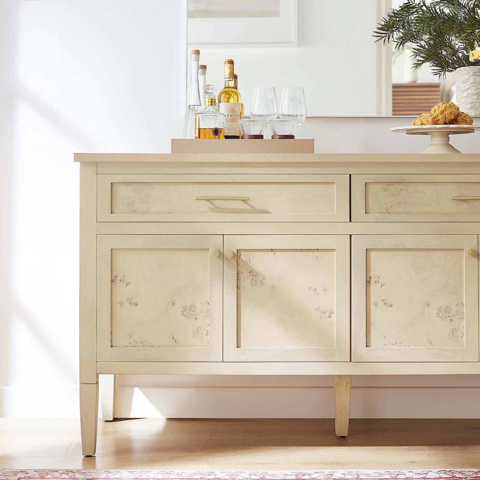 Bleached burl wood sideboard styled as a chic home bar with tray, glassware, and brass accents in a bright room || EEI-6794-BUR || detail_room