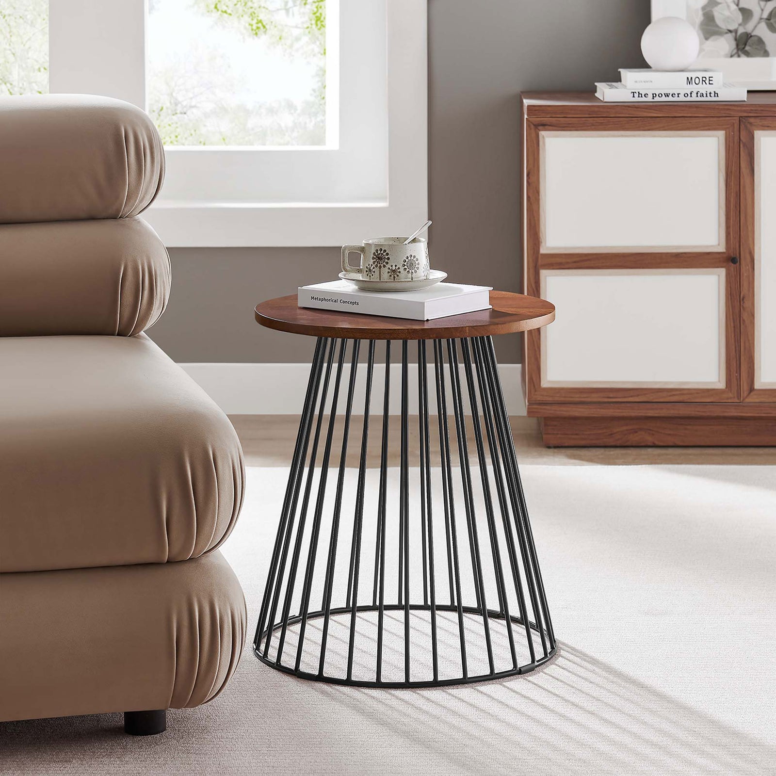 Walnut round side table with black metal base placed next to a modern sofa in a bright living room || EEI-6831-WAL || front_angle_room