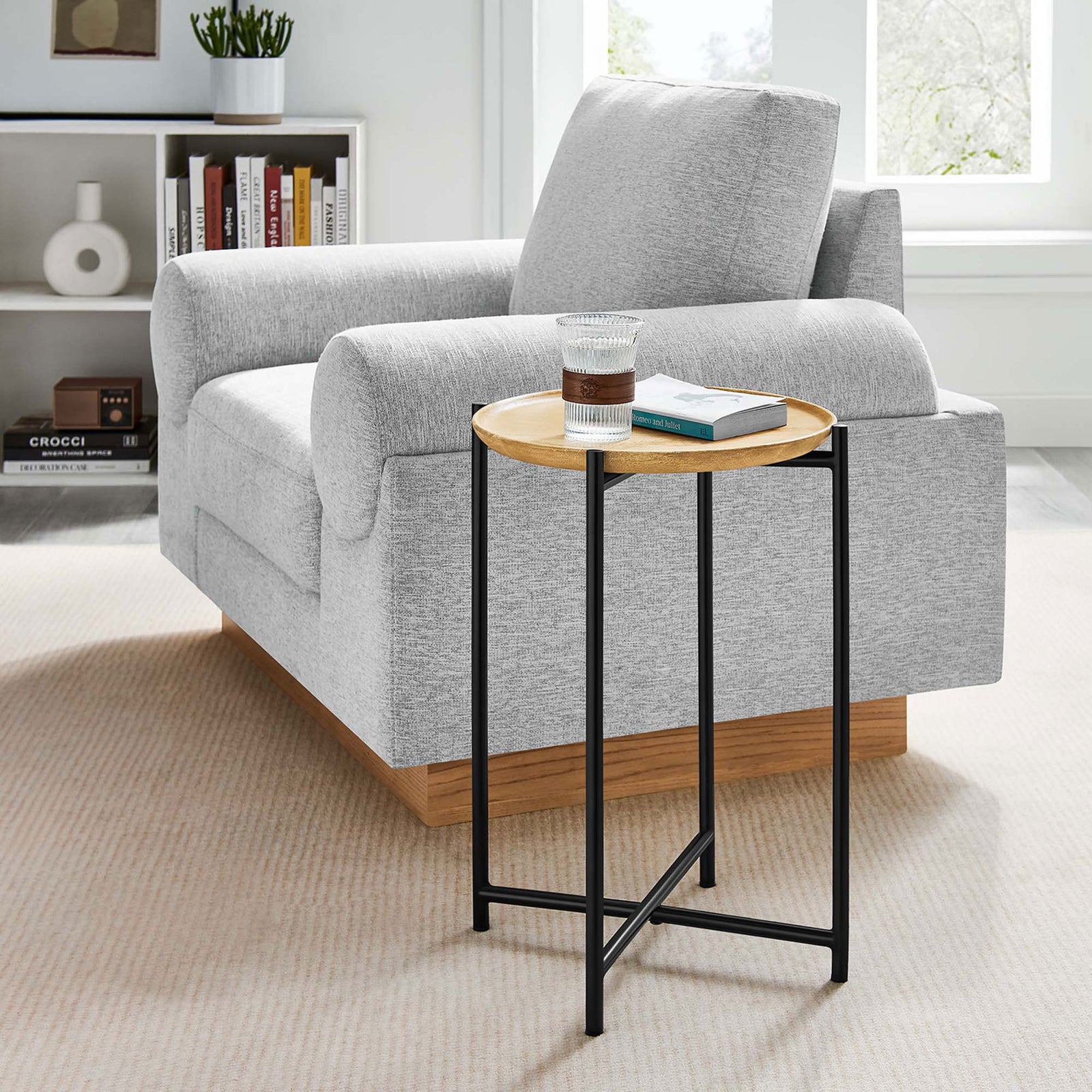 Round oak and black metal side table next to a sofa, perfect for drinks or a small plant || EEI-6832-OAK || front_angle_room