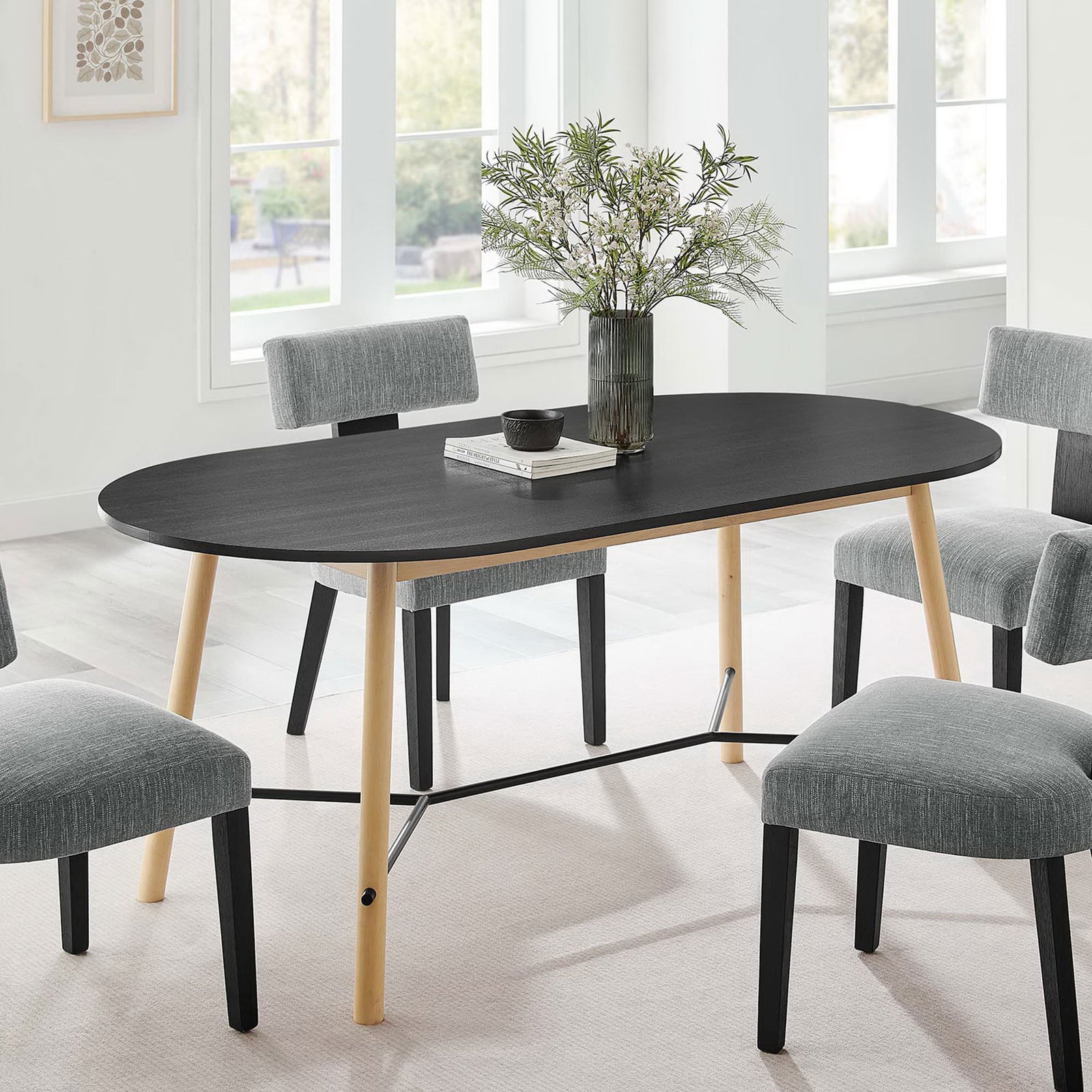 Black oval dining table styled with gray chairs and greenery, creating a welcoming modern dining space || EEI-6836-BLK-OAK || front_angle_room