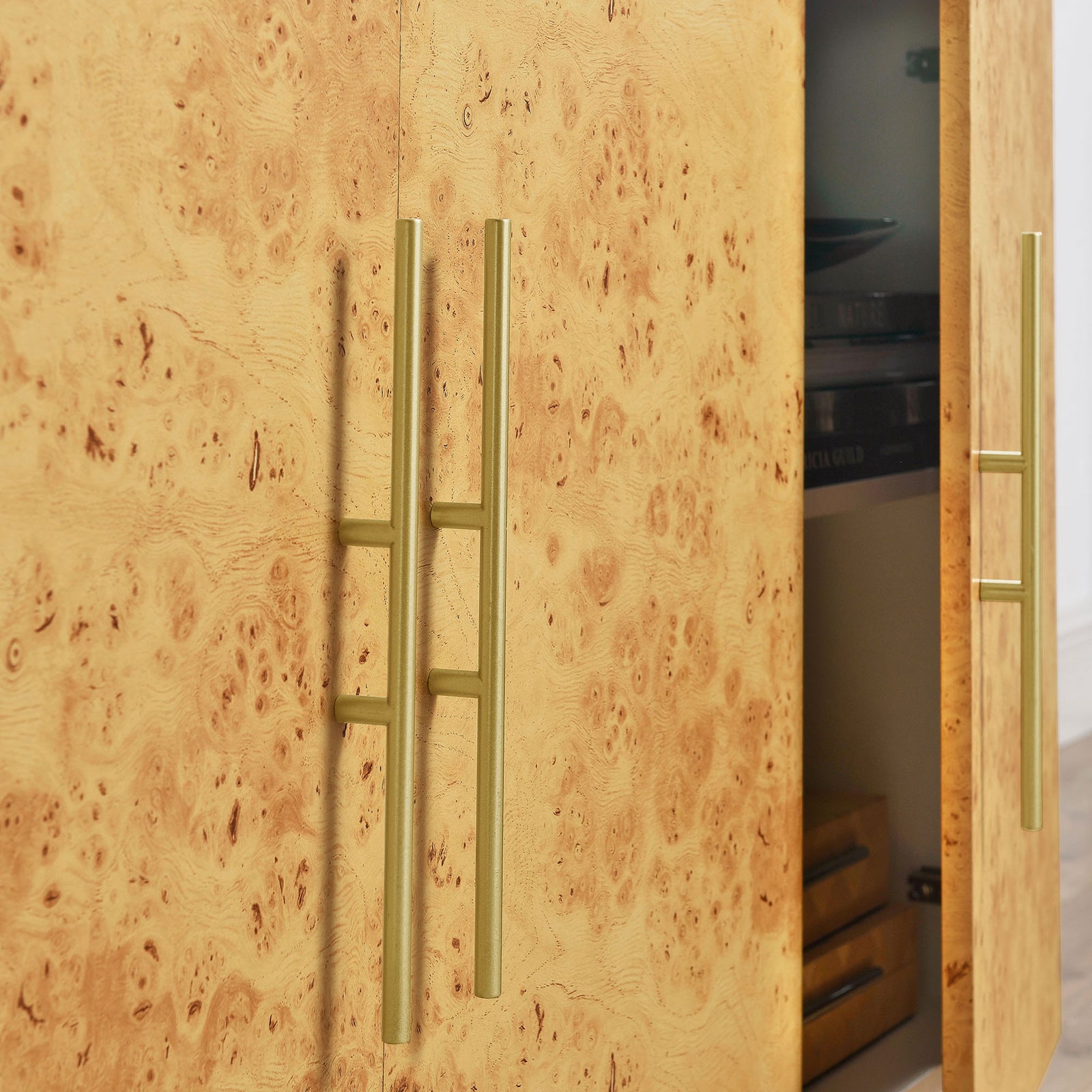 Close-up of gold-tone bar pulls against richly textured burl wood cabinet doors || EEI-6847-WHI-BUR || handle_studio
