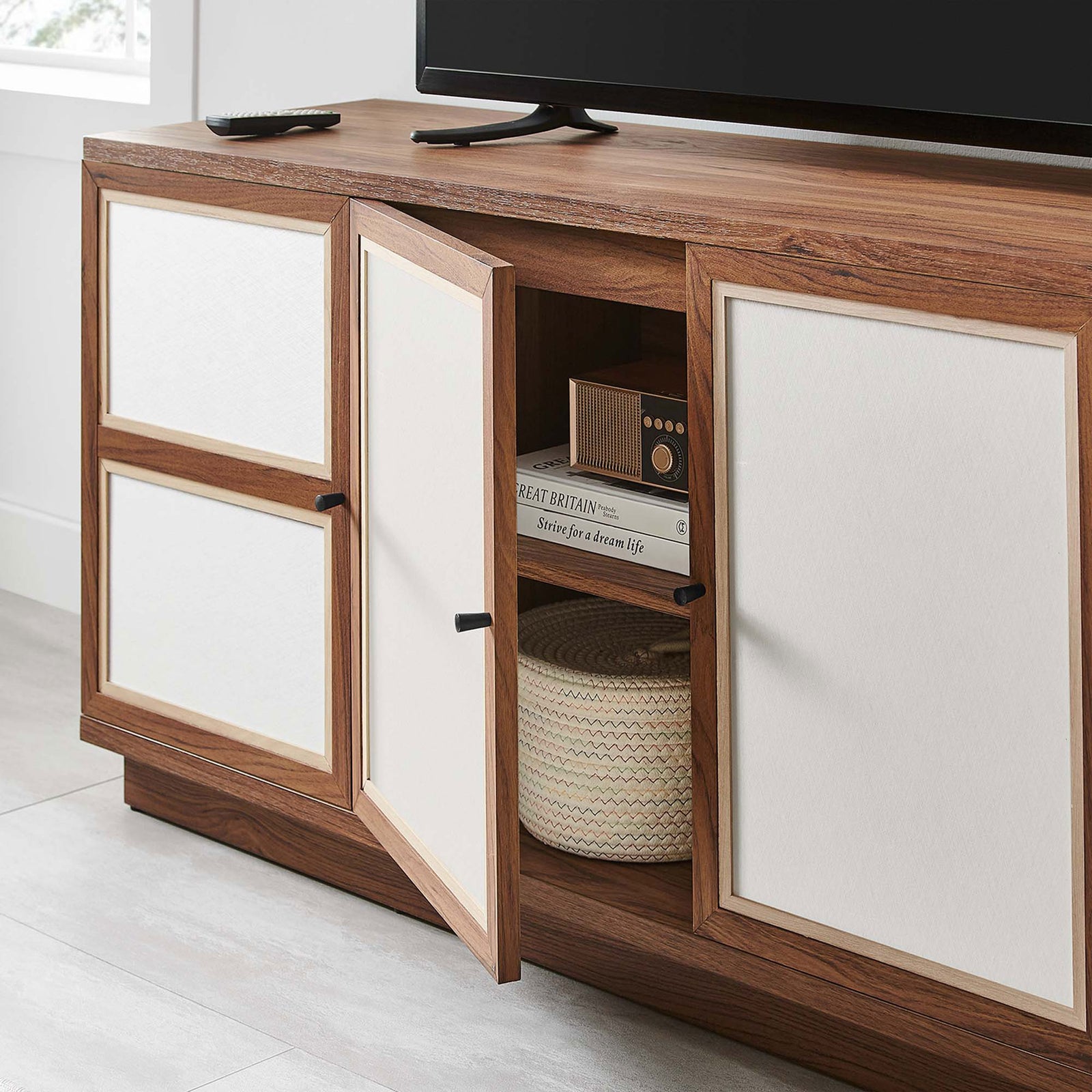 Capri TV console in a bright living room with a door open to reveal neatly organized baskets and books || EEI-6865-WAL || storage_open_room
