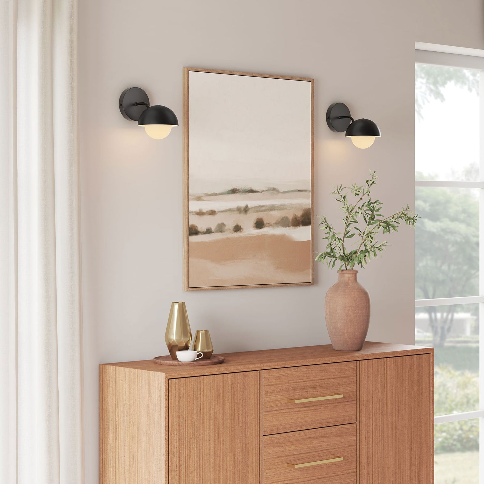 Pair of black globe sconces flank artwork to bathe the console vignette in cozy ambient light || EEI-6871-BLK || front_angle_on_room