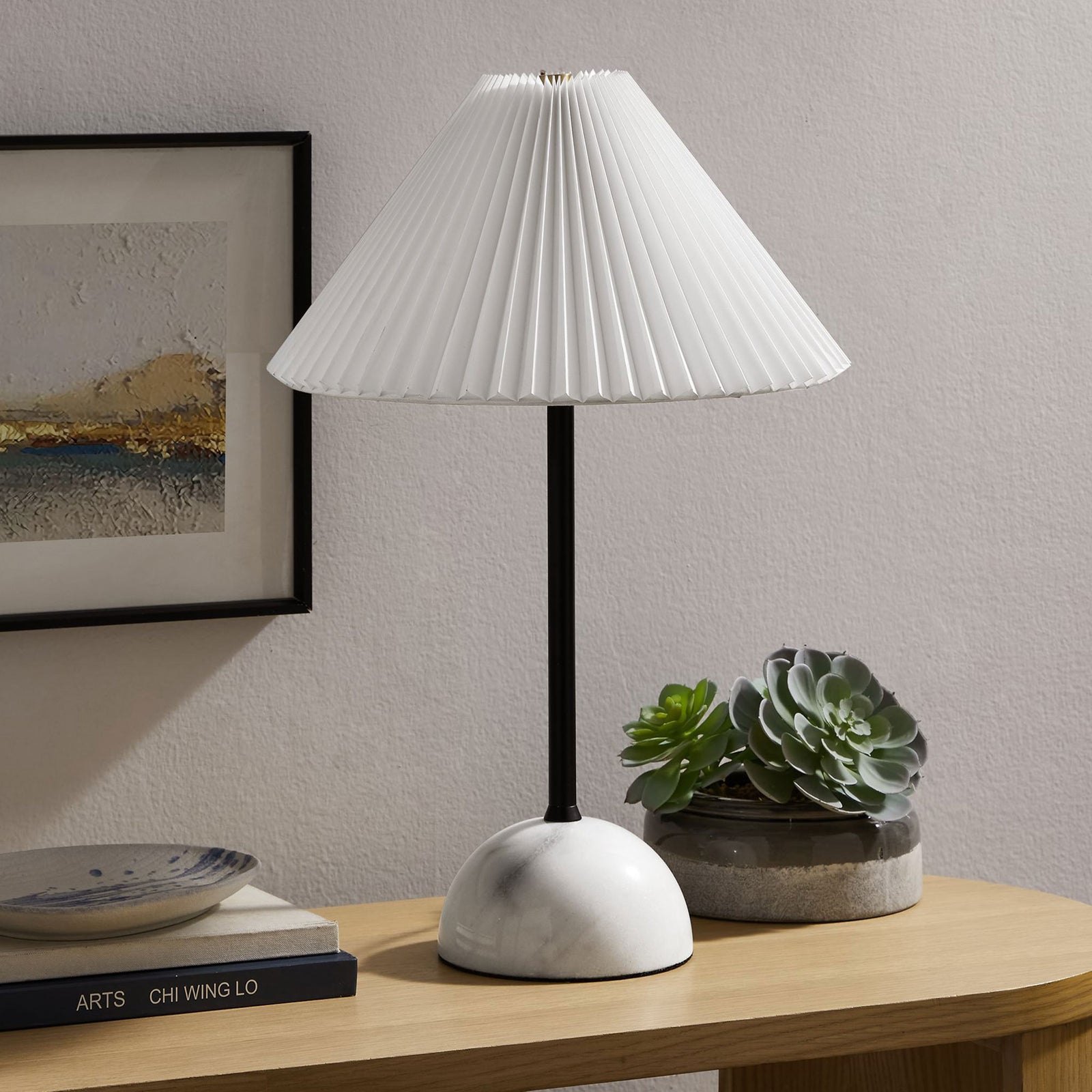 Illusion lamp accenting a console table with its slim black stem and rounded marble base. || EEI-6878-BLK || front_angle_room