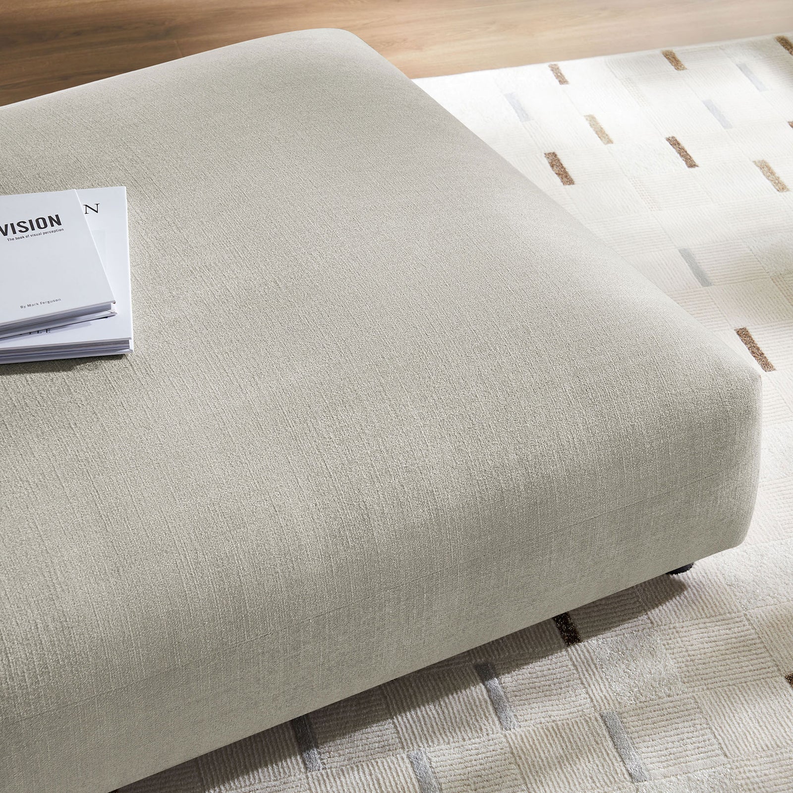 Linen ottoman blends with contemporary decor, pairing its soft woven texture with a patterned rug and wood flooring || EEI-6889-LIN || detail_room