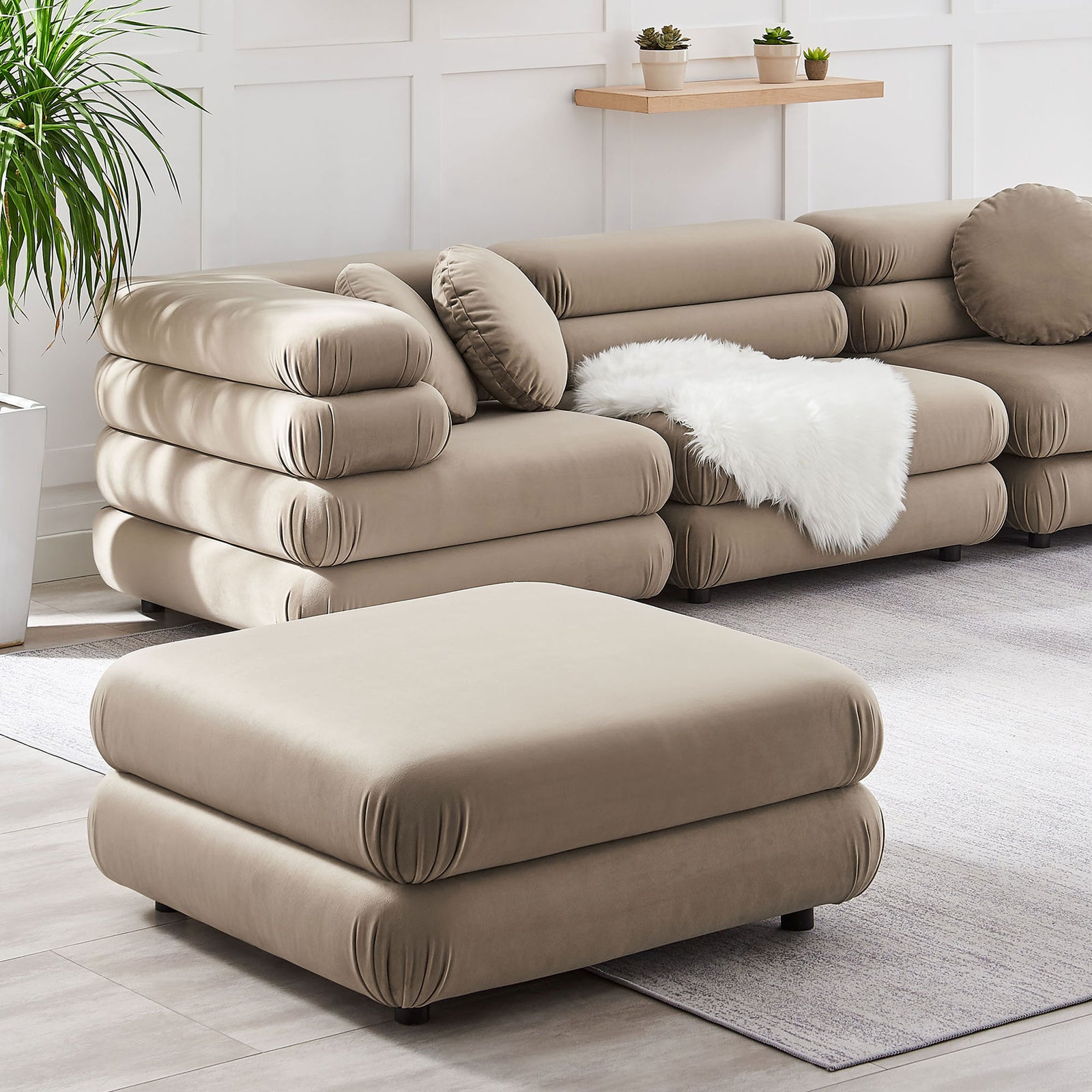 Taupe velvet ottoman styled with matching modular seating to create a cozy, layered lounge look || EEI-6899-TAU || front_angle_room