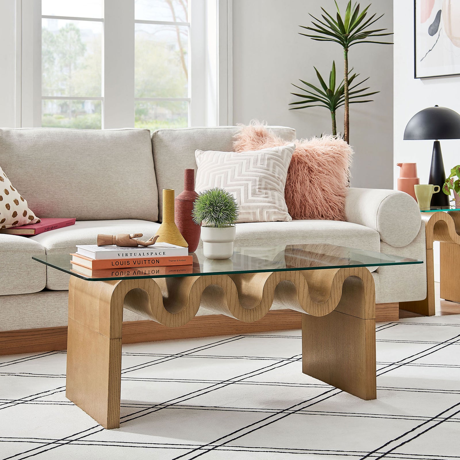Modern coffee table anchors the room with a clear glass top and sculptural natural base || EEI-6900-NAT || front_angle_room