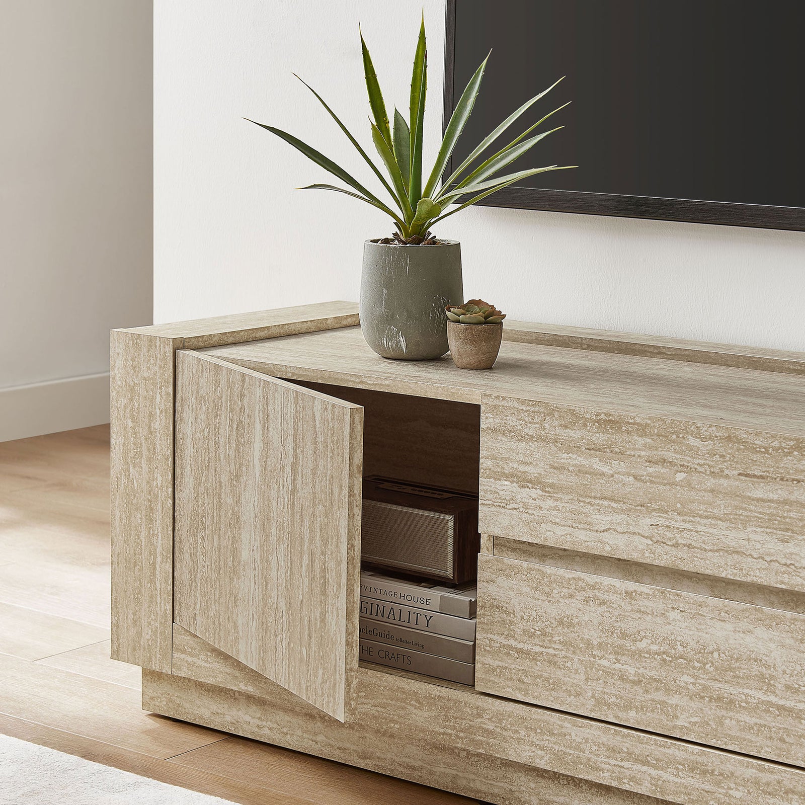TV stand styled with decor and a door ajar, revealing shelved storage for books and living room objects || EEI-6907-TRA || storage_open_room