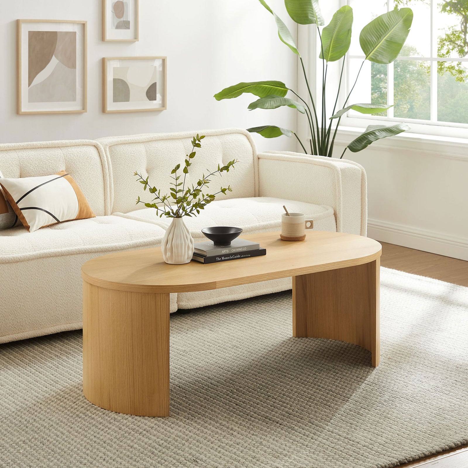 Modern oval coffee table brings natural warmth to a bright living room || EEI-6911-OAK || front_angle_room