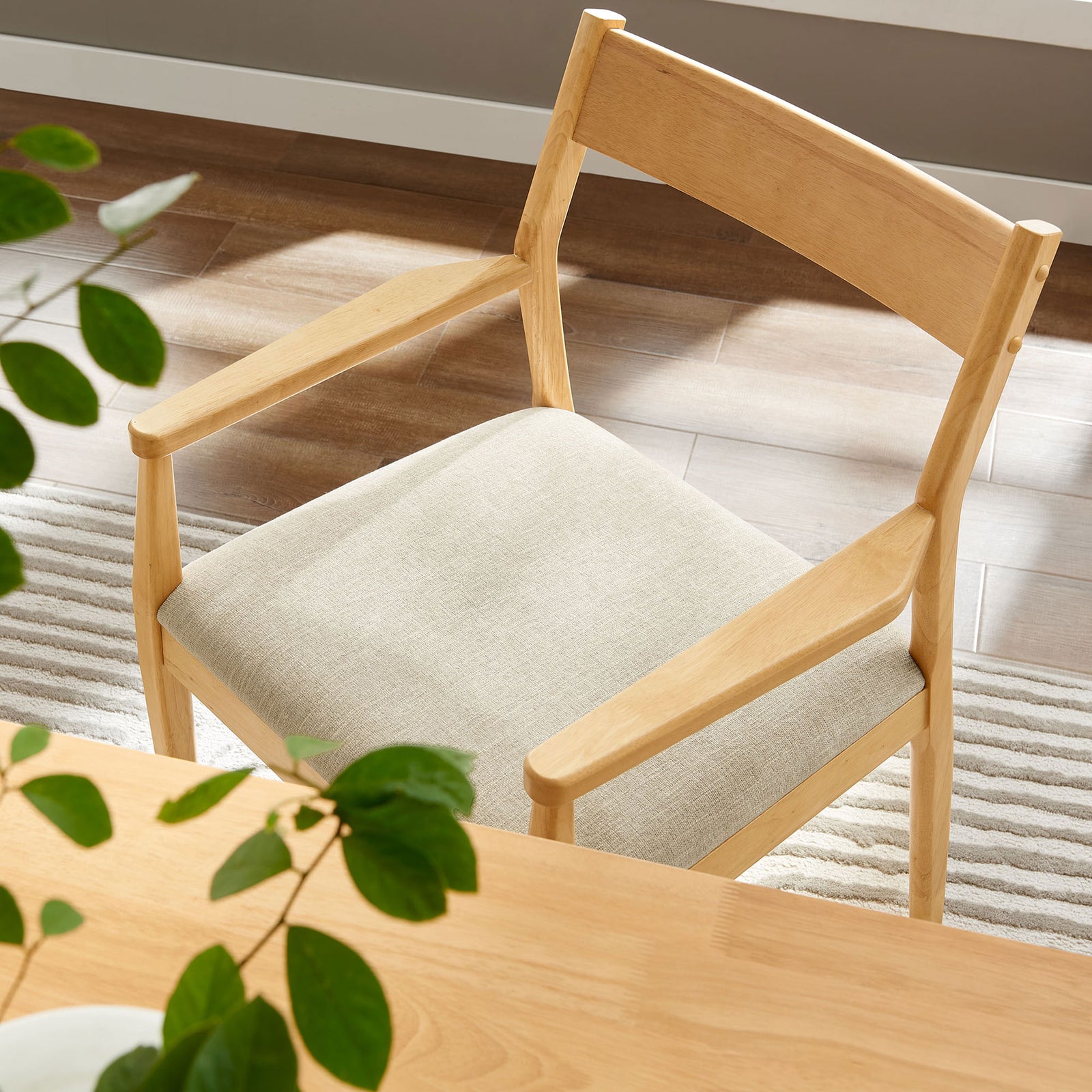 Solara dining armchair tucked at a light wood table with heathered beige cushion in a bright dining room. || EEI-6916-NAT-HEB || detail_room