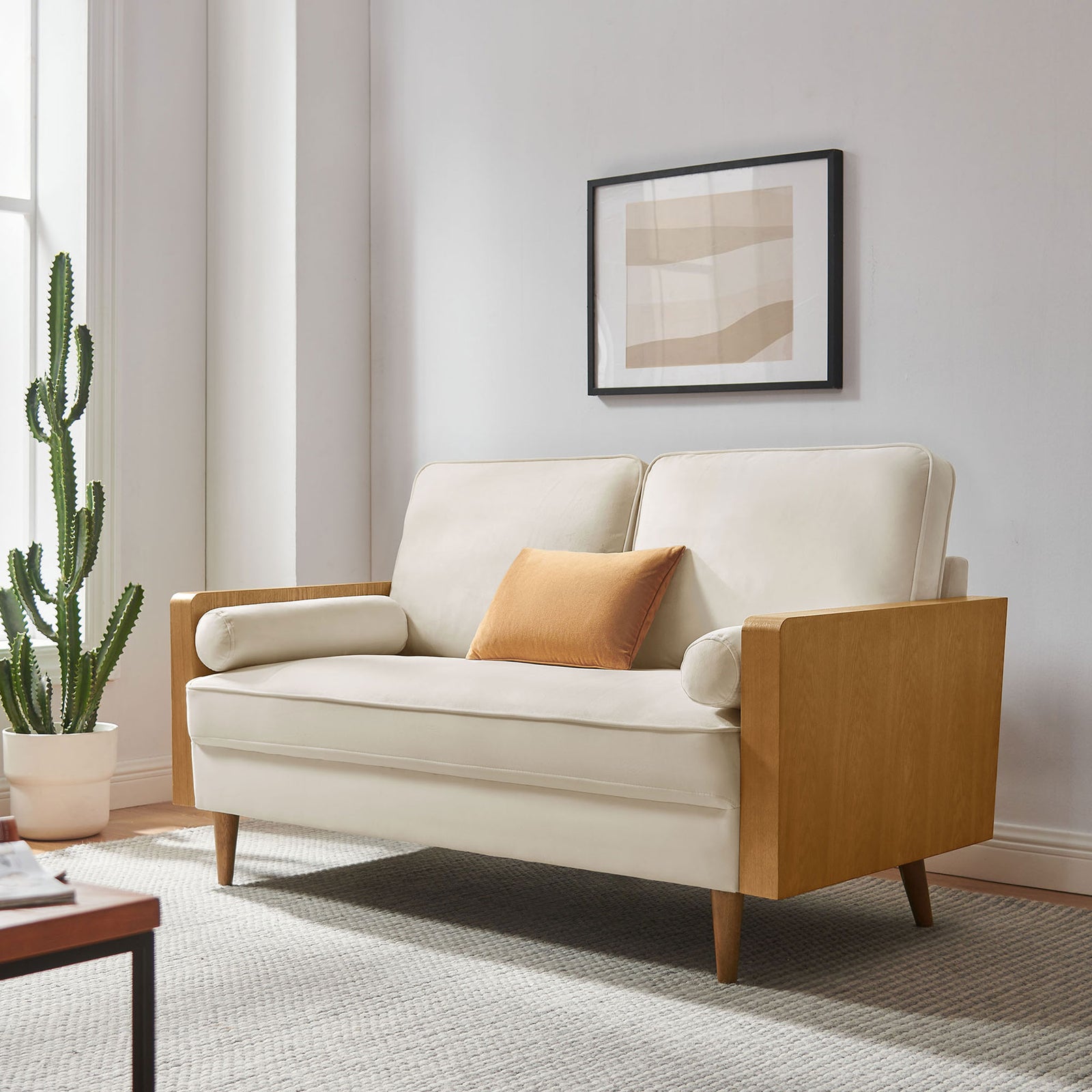 Cream velvet loveseat with walnut arms styled in a bright modern living room with artwork and greenery || EEI-6945-WAL-ALA || front_angle_room