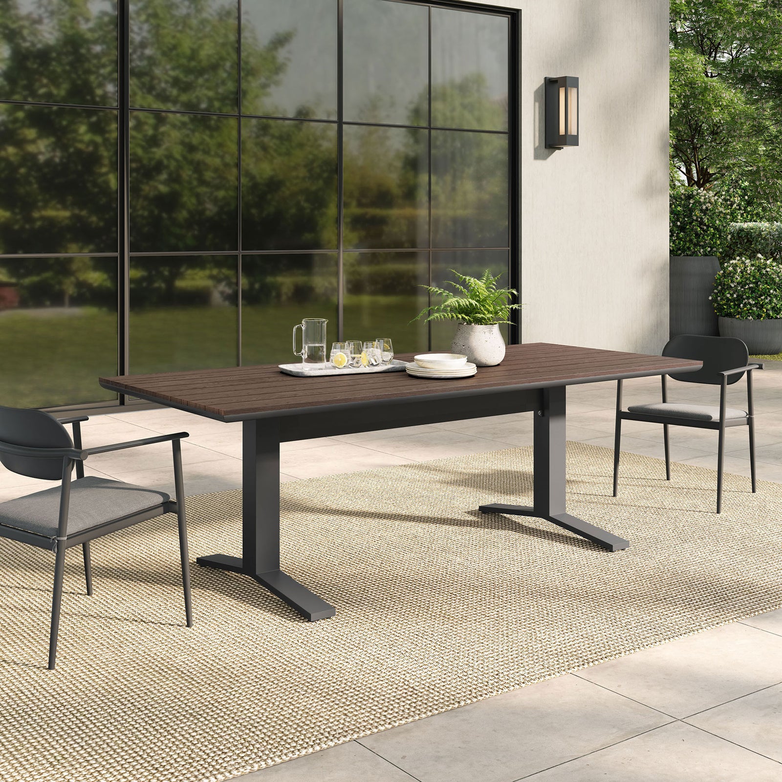 Gavelston gray wash outdoor dining table styled on a modern patio with coordinating chairs and greenery. || EEI-6948-GWA-GRY || front_angle_room