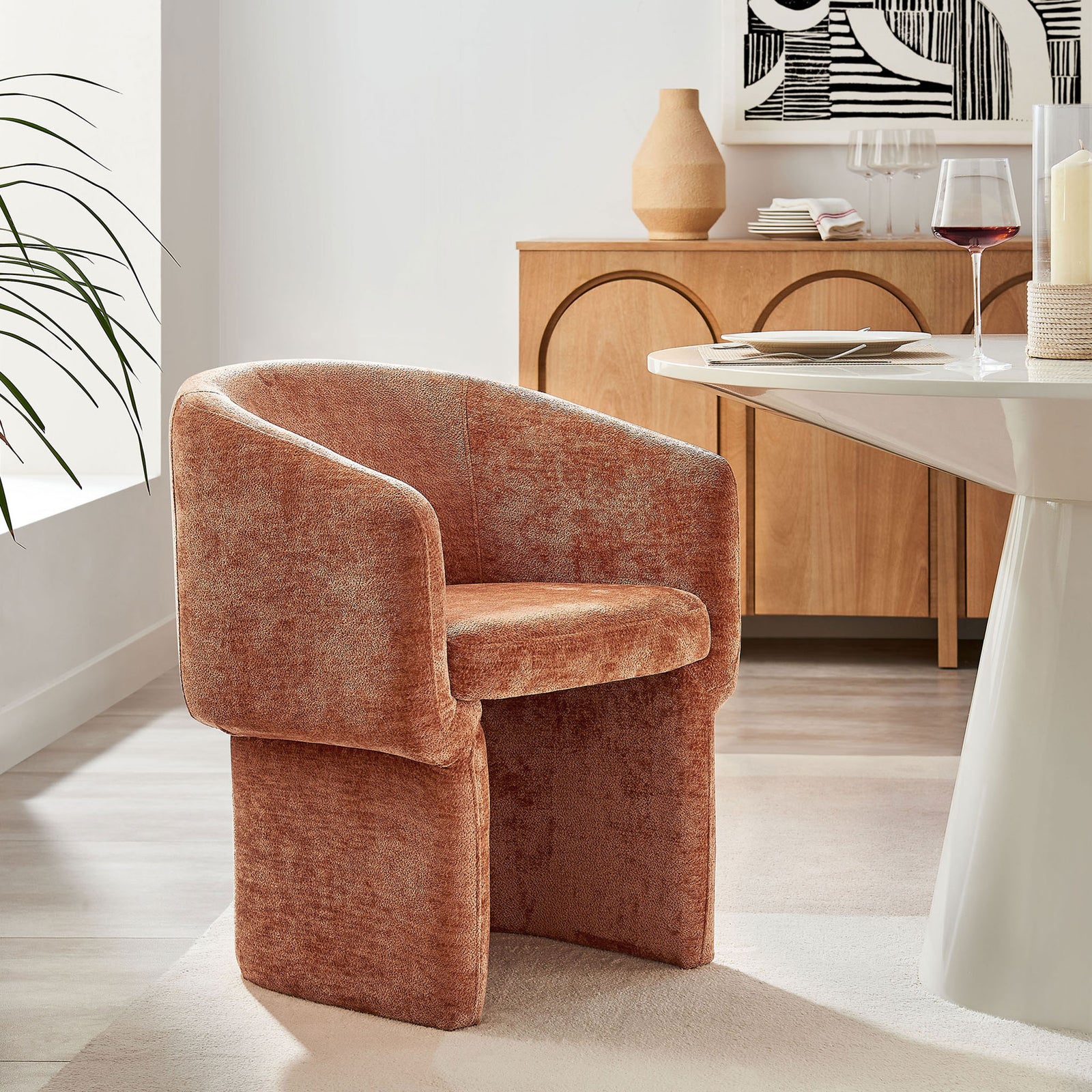 Verity rust chenille dining armchair paired with a modern white table and wood sideboard in a chic dining space || EEI-6951-RUS || front_angle_room
