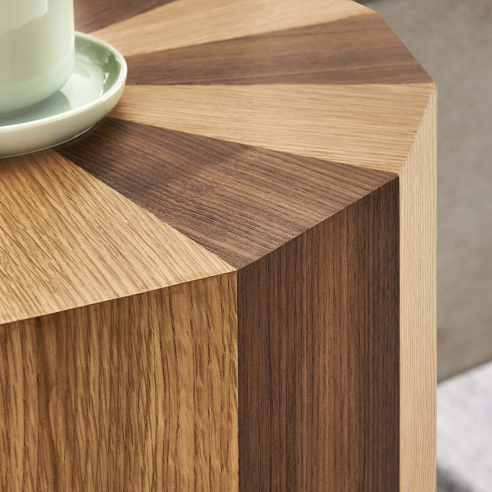 Rich oak and walnut surface of the Twirl table styled with a mug in a cozy living room setting || EEI-6952-OAK-WAL || detail_room