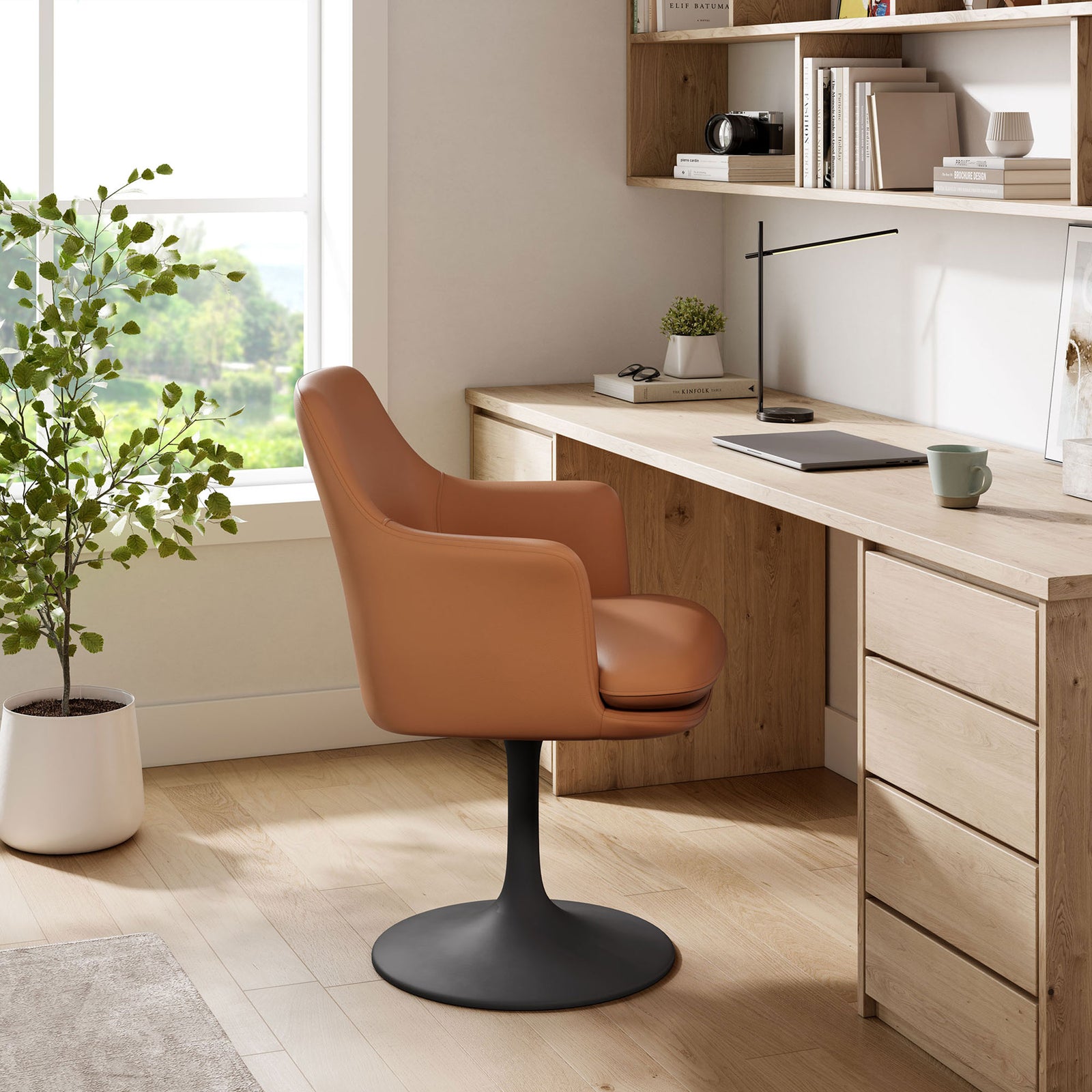 Tan vegan leather swivel armchair with black pedestal base styled as a modern desk chair in a bright workspace || EEI-6958-BLK-TAN || side_room