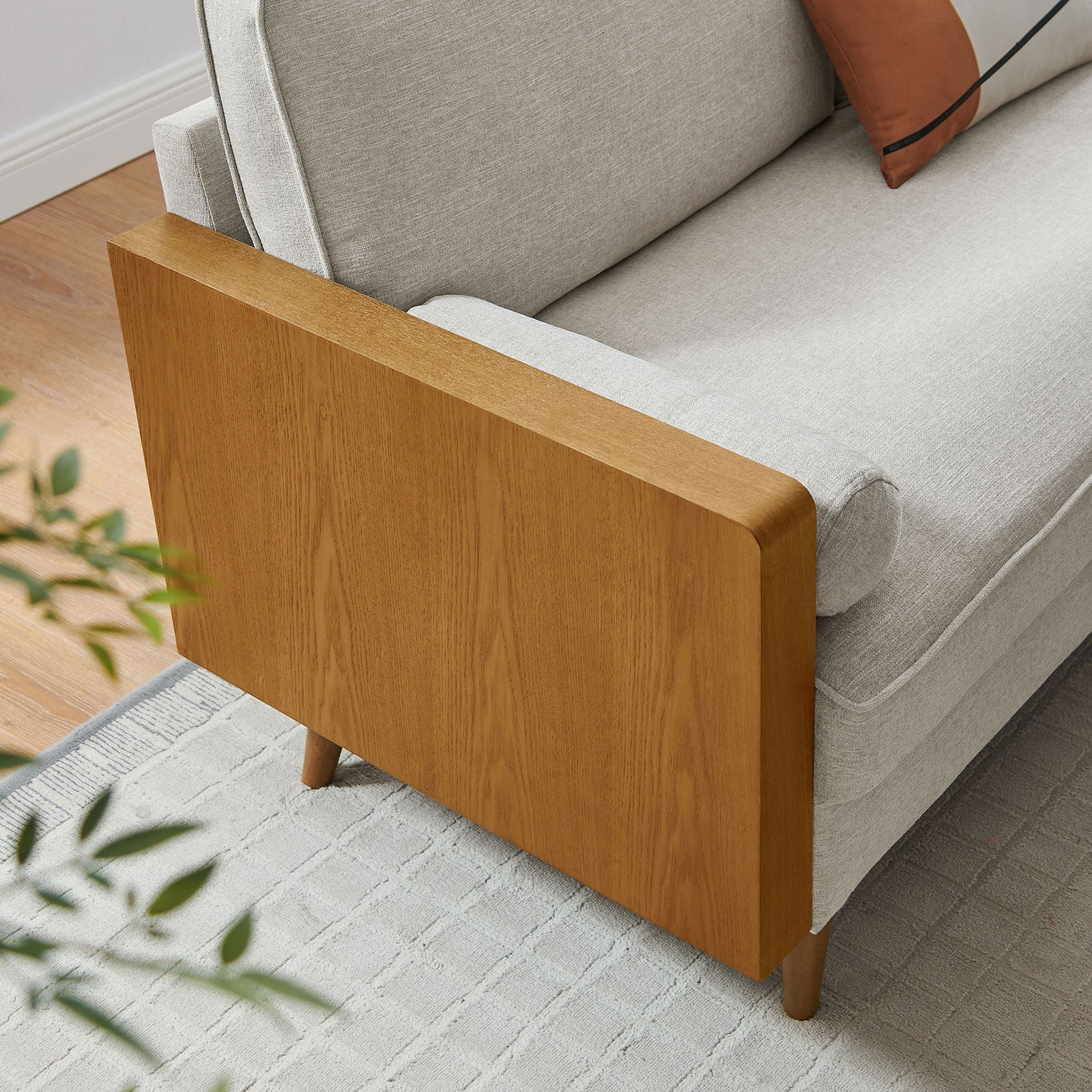 Walnut-trimmed sofa corner styled in a modern living room with neutral rug and greenery. || EEI-6961-WAL-HEI || detail_room