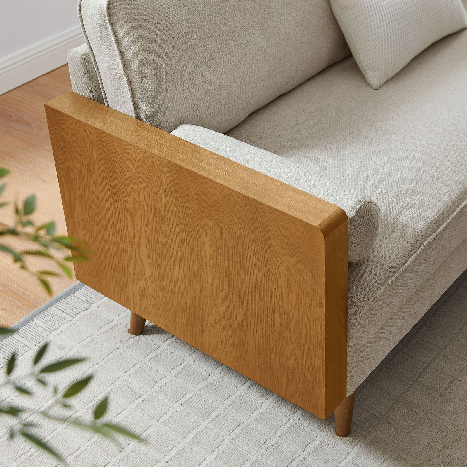 Wood side panel and beige cushions pair with a textured rug to bring warm mid-century style to the living room || EEI-6961-WAL-HLB || detail_room