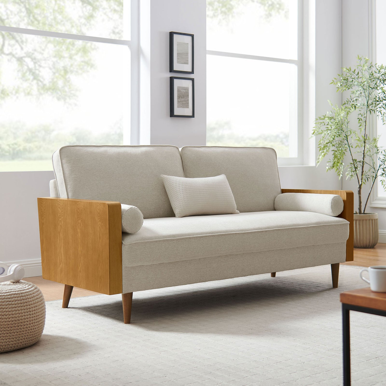 Mid-century sofa in a bright living room, featuring beige heathered cushions, wood arms, and tapered legs || EEI-6961-WAL-HLB || front_angle_room