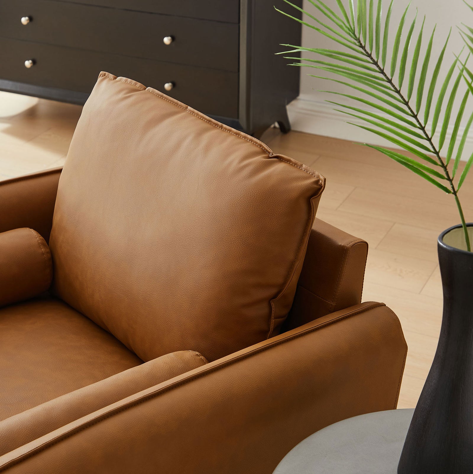 Soft back cushion and round bolster pillow in tan vegan leather for inviting, lounge-ready comfort. || EEI-6973-TAN || detail_room