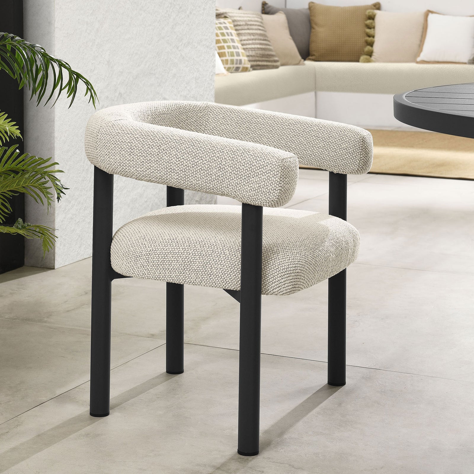 Ivory upholstered patio dining chair styled beside a graphite table in a bright, modern outdoor lounge || EEI-6979-IVO-GPH || front_angle_room