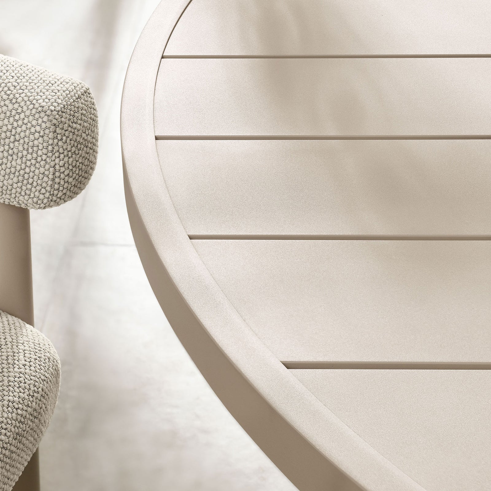 Taupe slatted round tabletop with subtle matte finish, styled with greenery above pale stone tile flooring || EEI-6981-TAU || detail_room