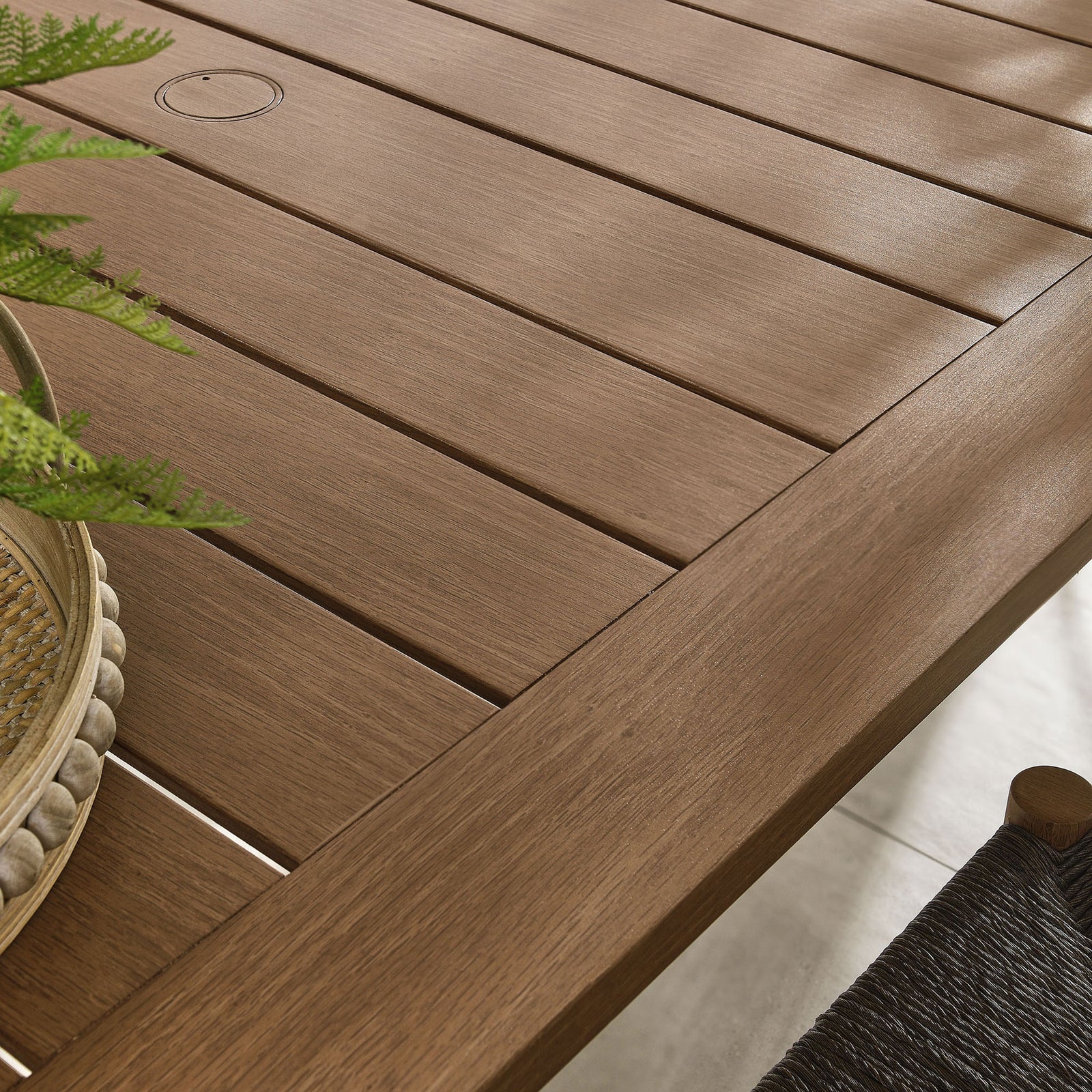 Rich walnut wood-grain slats complement woven chairs and greenery for a cozy outdoor dining nook || EEI-6985-WAL || swatch_room