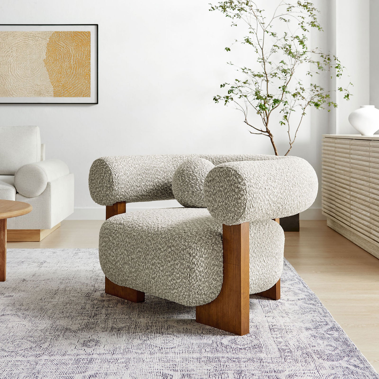 Elevates modern interiors with rounded contours, textured boucle upholstery, and warm ash wood accents. || EEI-6996-RIV || front_angle_room