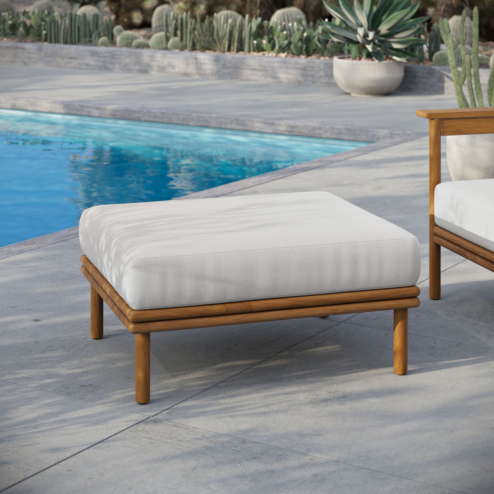 Bright white cushion and teak frame bring spa-like ease to a serene poolside seating area. || EEI-7009-NAT-SAI || front_angle_room