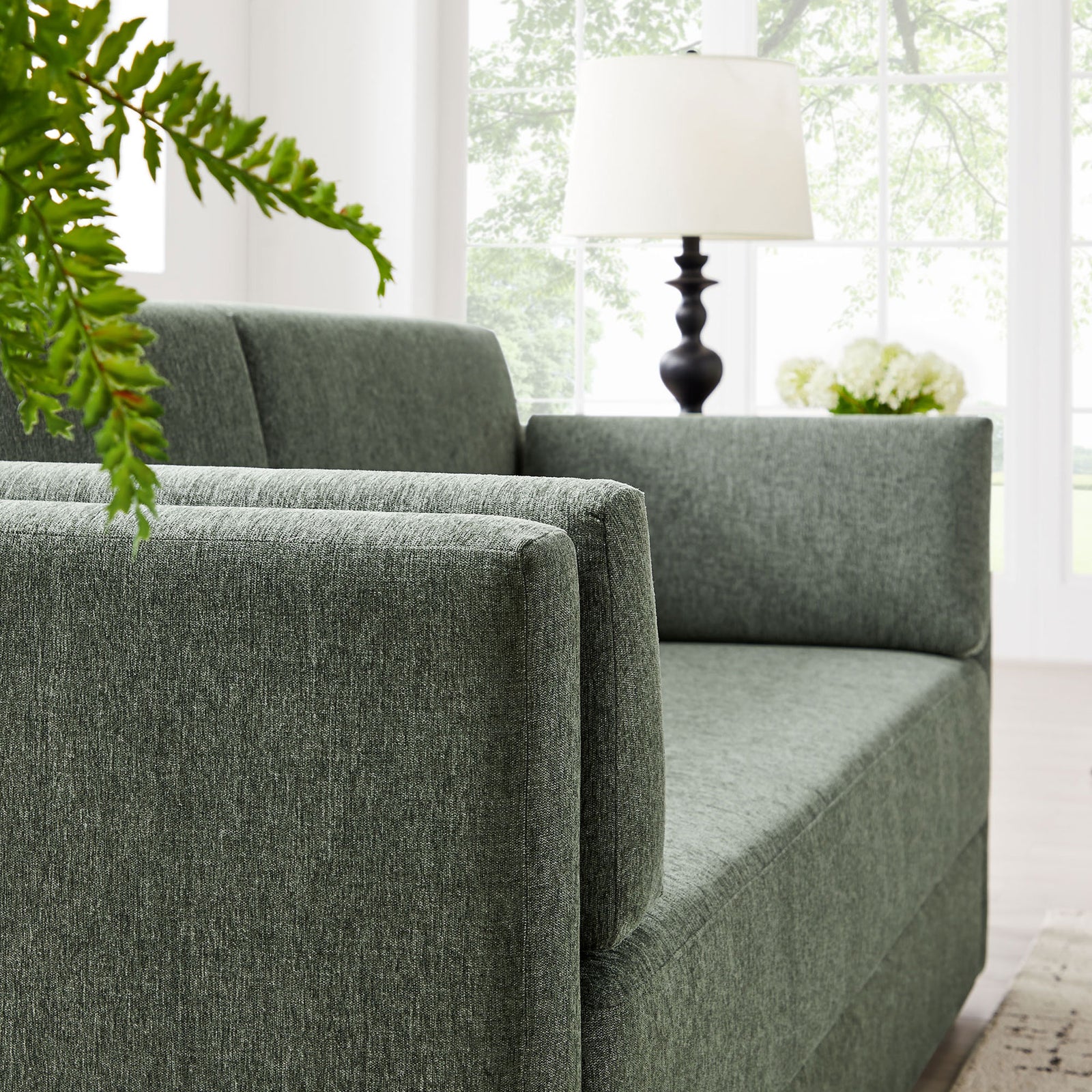 Eucalyptus green Linden sofa styled in a bright living space with airy windows and fresh greenery || EEI-7012-EUC || detail_room