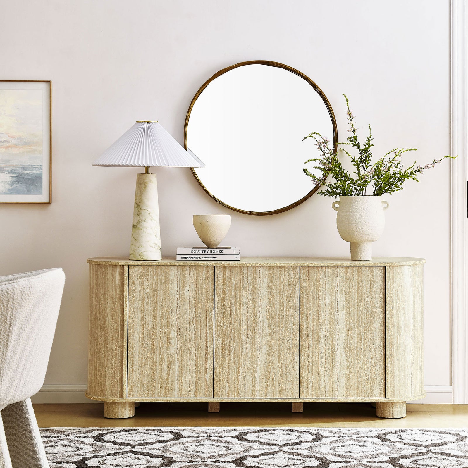 Sideboard in travertine finish anchors a bright living space with ample concealed storage and rounded form. || EEI-7015-TRA || front_room