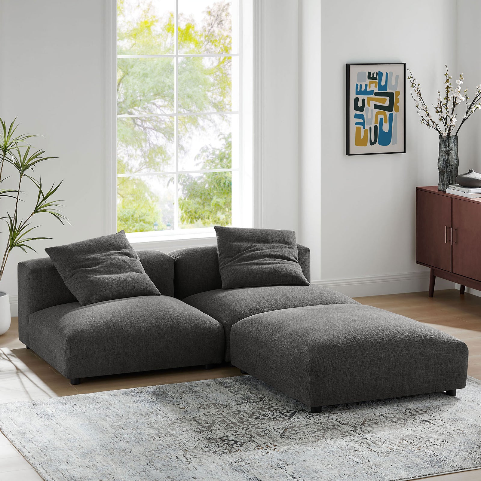 L-shaped charcoal modular sectional creating a cozy corner lounge in a contemporary living room || EEI-7029-CHA || front_angle_room