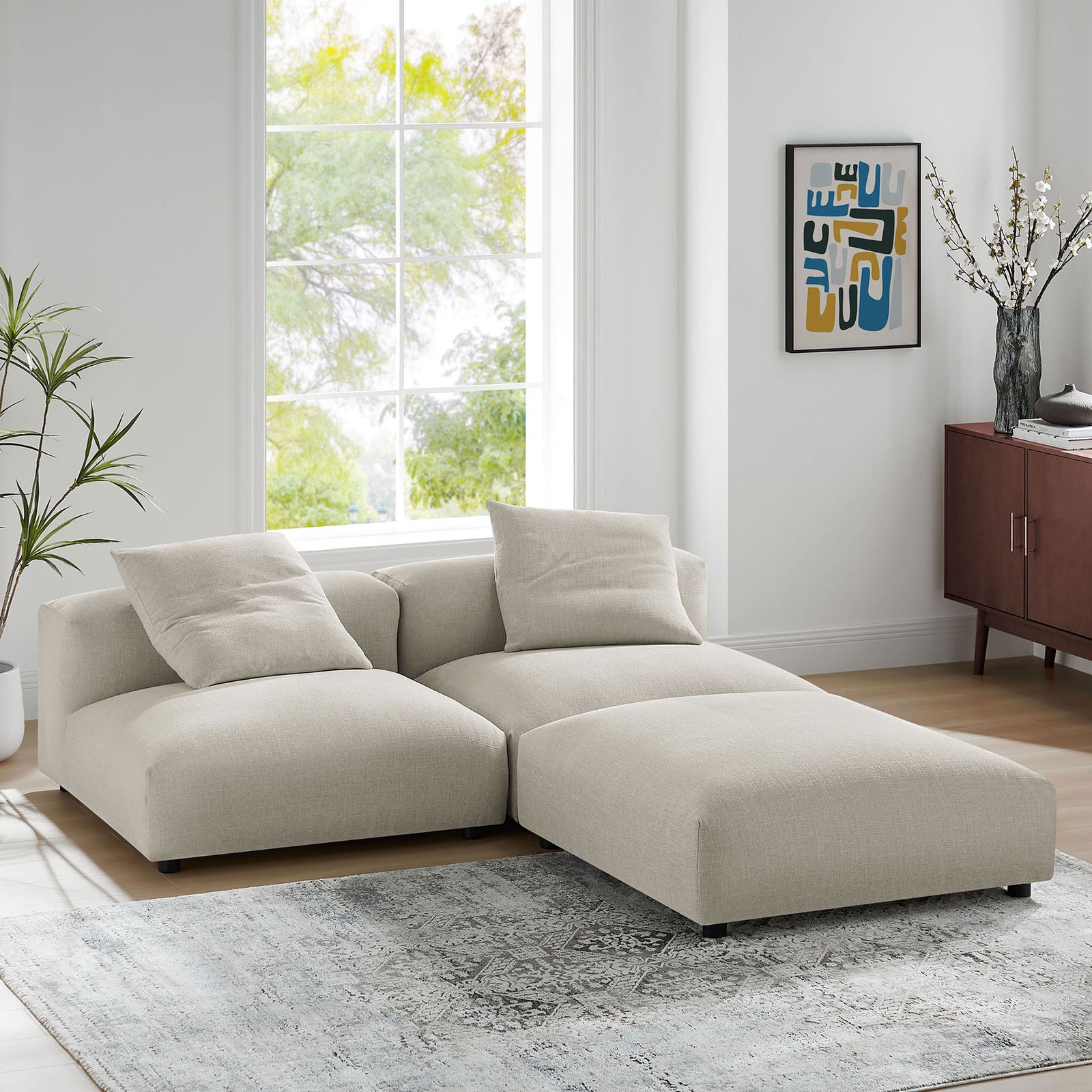 L shaped linen modular sectional forming a chaise lounge in a modern sunlit living room || EEI-7029-LIN || front_angle_room