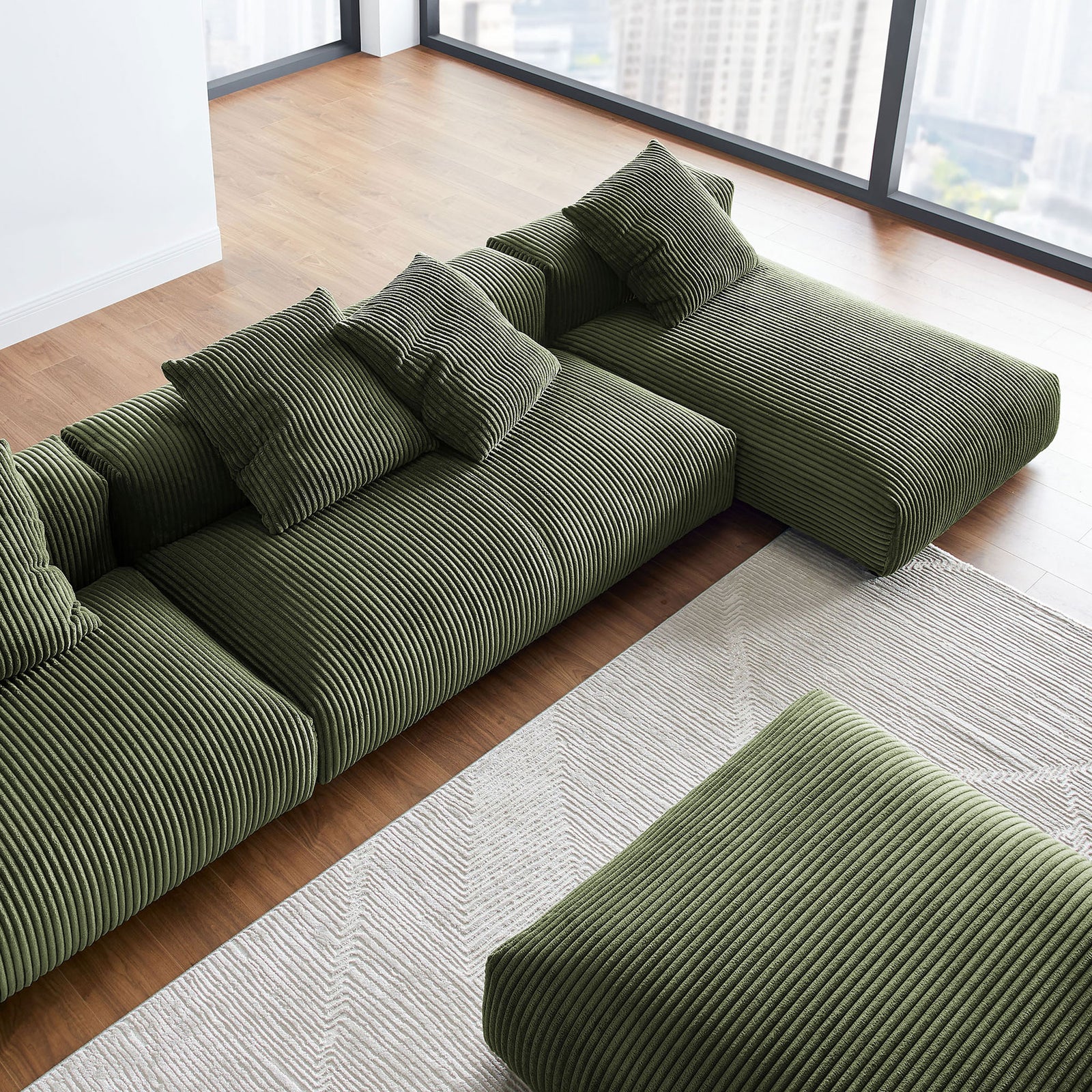 Overhead view of plush modular sectional with chaise and ottoman in bright city loft setting || EEI-7032-FRN || detail_room