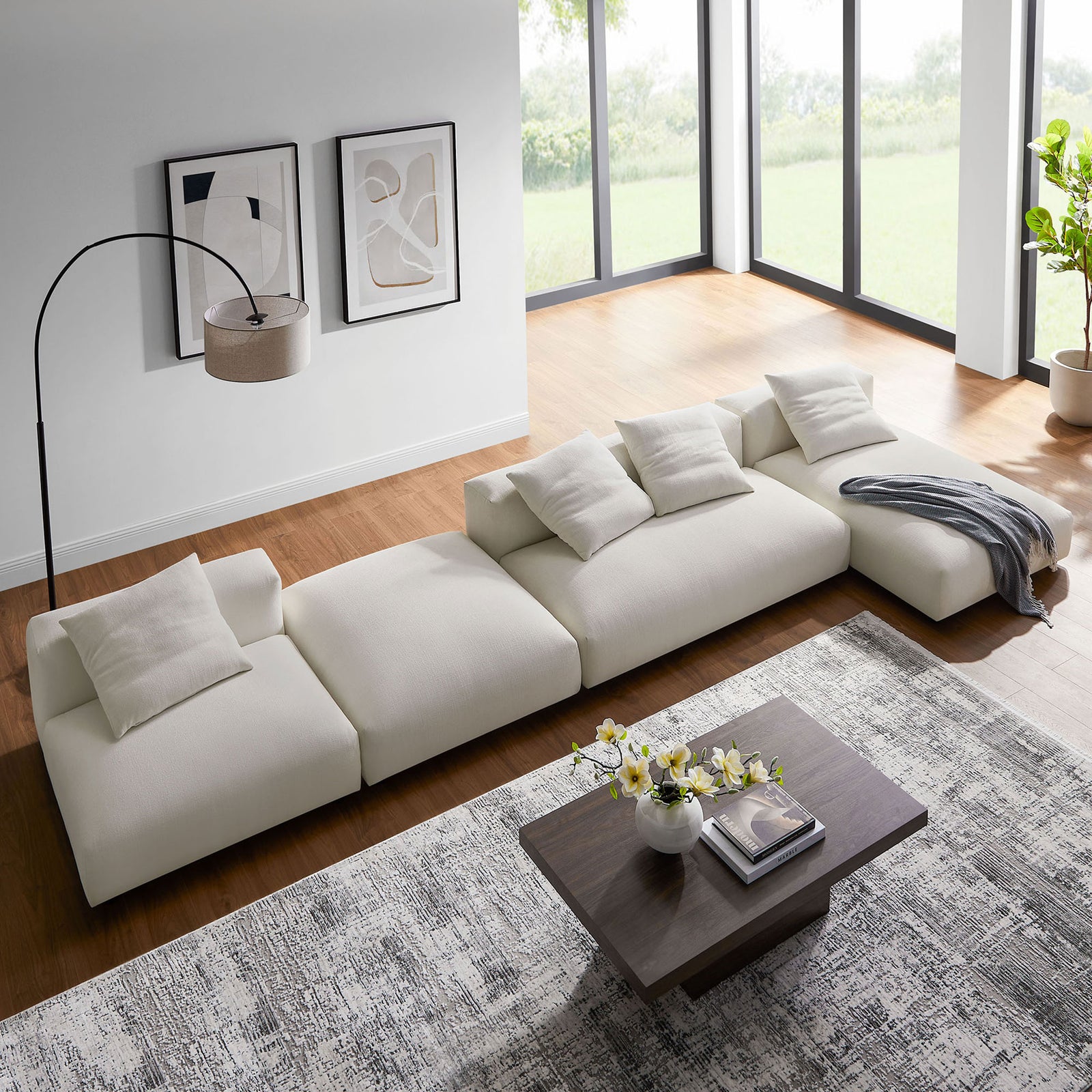 Relaxed lounge style salt modular sectional with ottoman, throw blanket, and modern coffee table on layered rugs || EEI-7033-SAL || top_angle_room