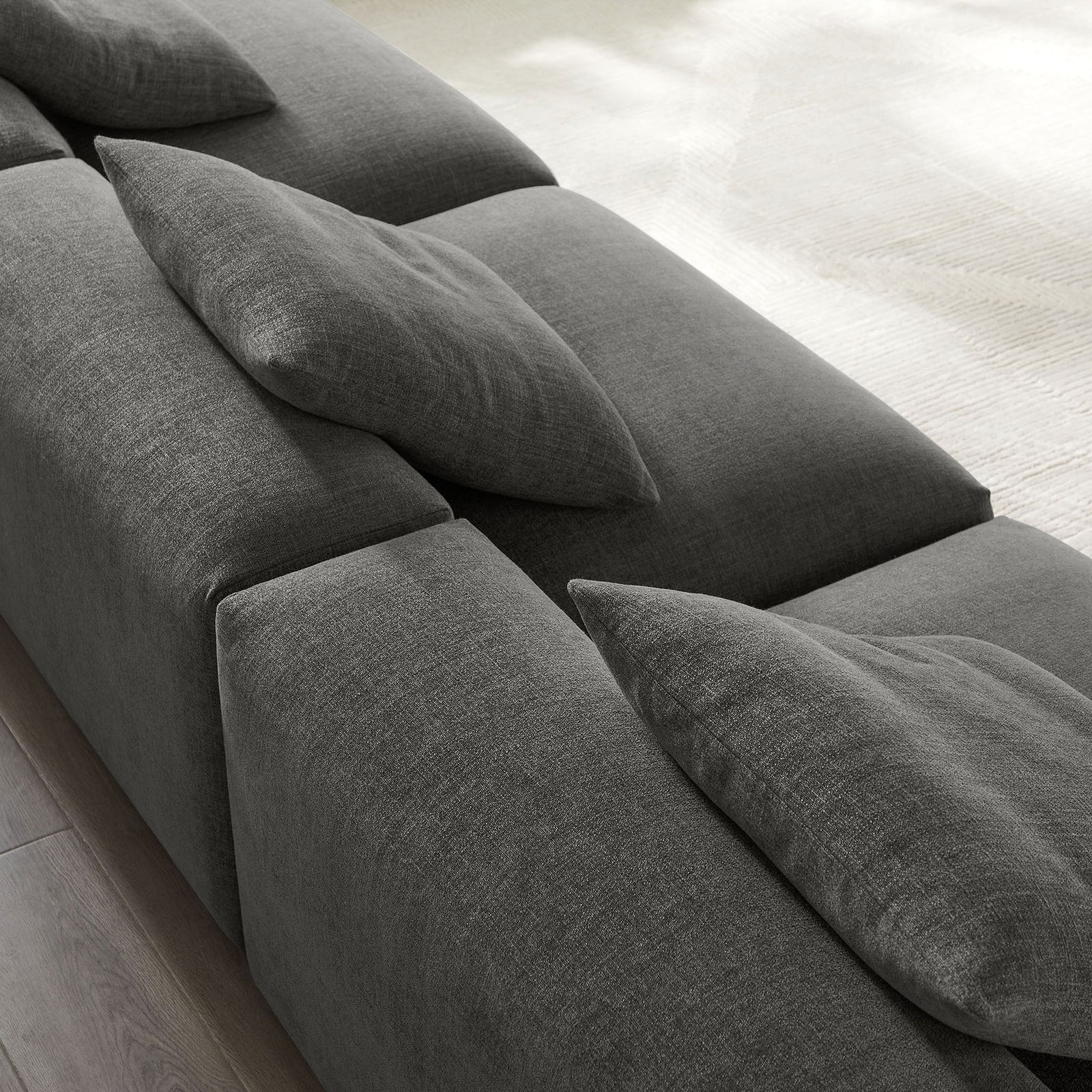 Charcoal modular sofa detail showing textured woven fabric and plush accent pillows across the seats || EEI-7035-CHA || detail_room