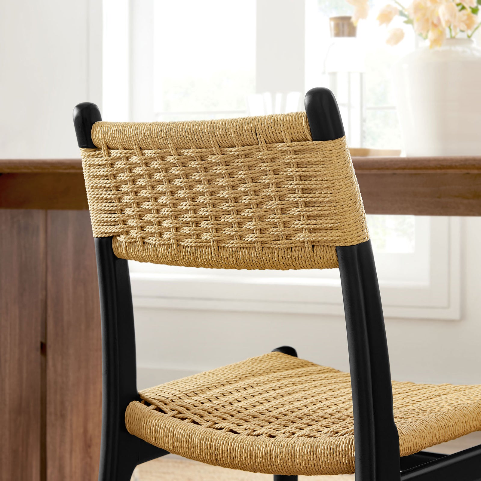 Natural rope backrest of black wood dining chair styled in a bright dining room || EEI-7044-BLK-NAT || detail_room