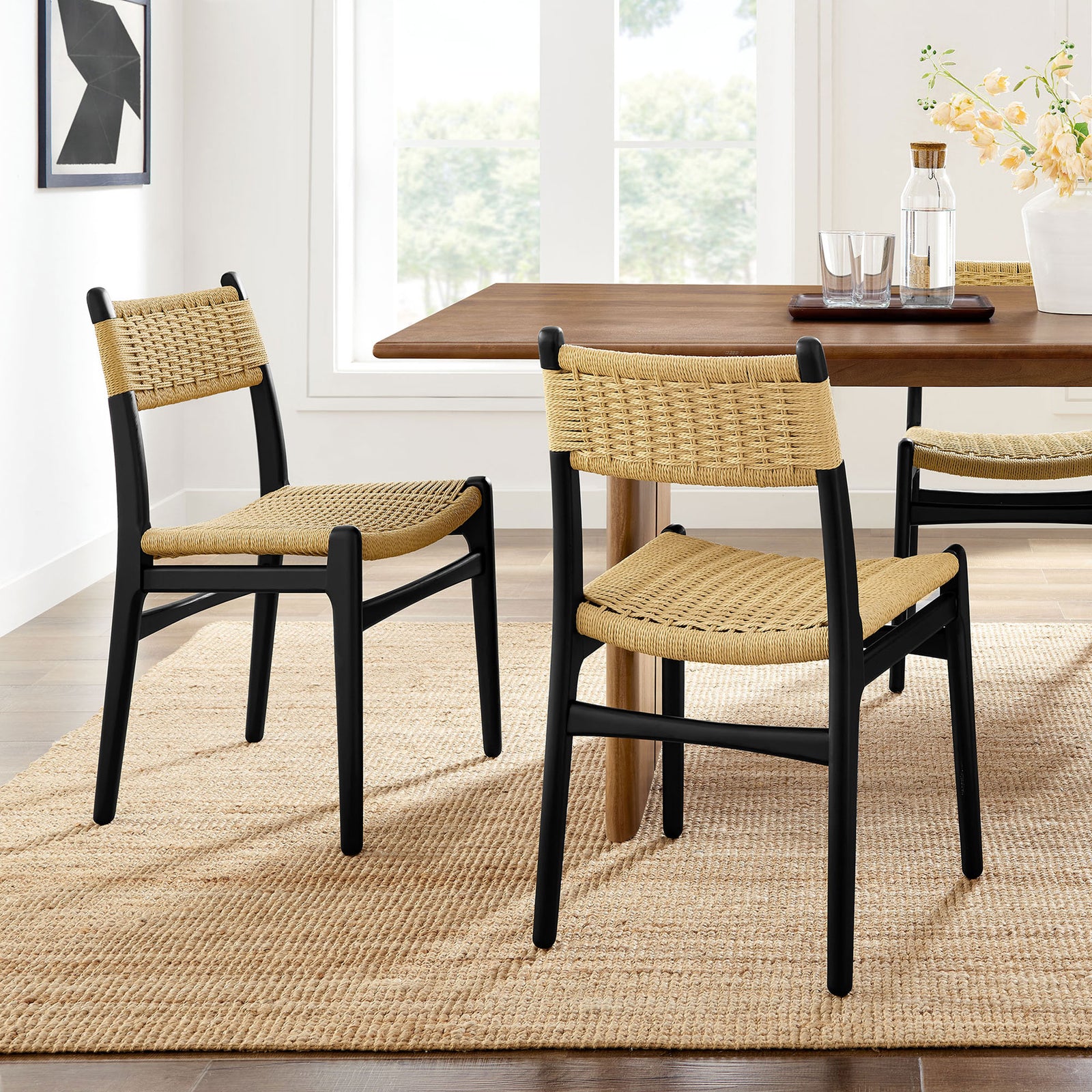 Pair of rope and wood dining chairs beside a modern table on a natural fiber rug || EEI-7044-BLK-NAT || front_angle_multi_room