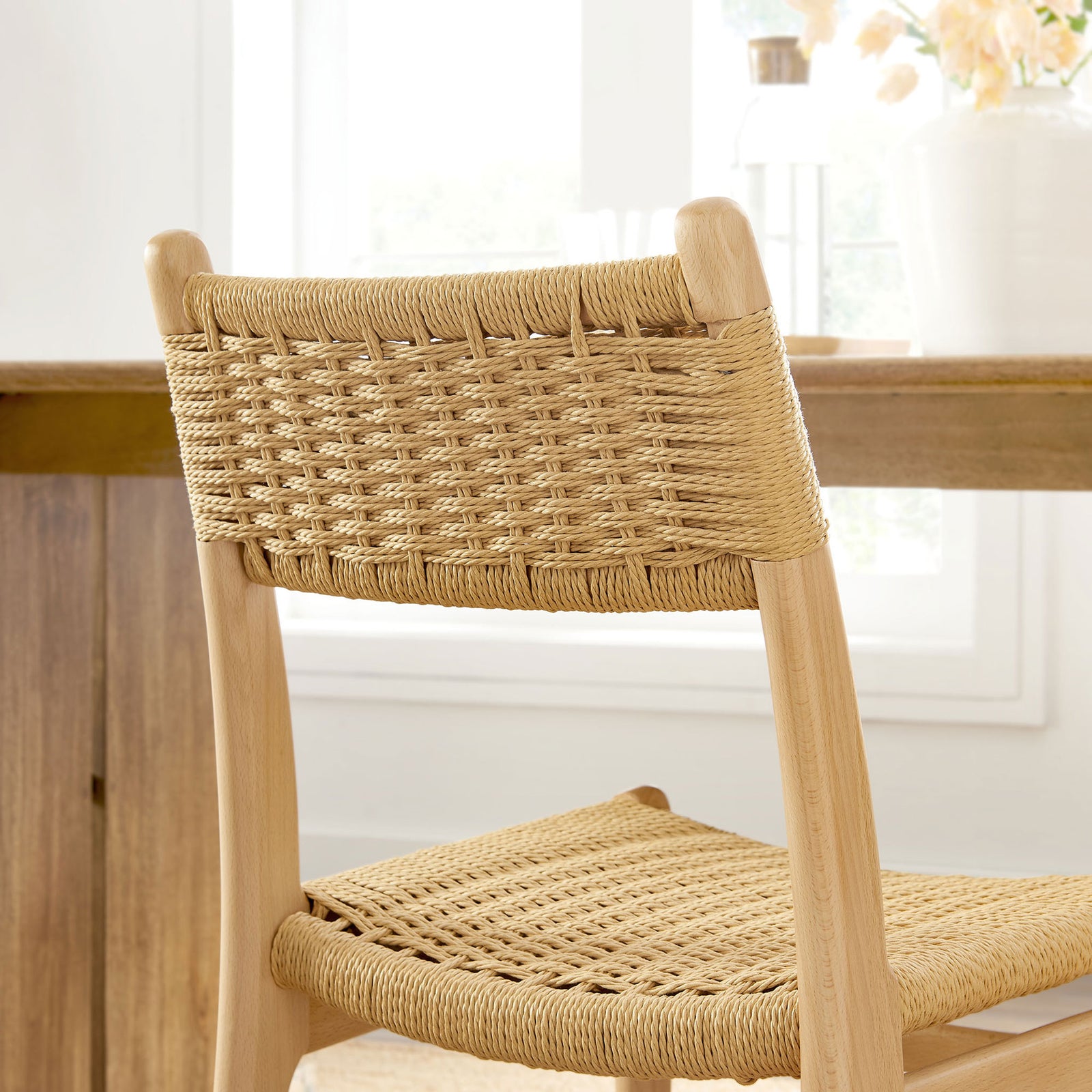 Natural rope backrest and light wood frame add relaxed, organic texture to a bright dining space. || EEI-7044-NAT-NAT || detail_room