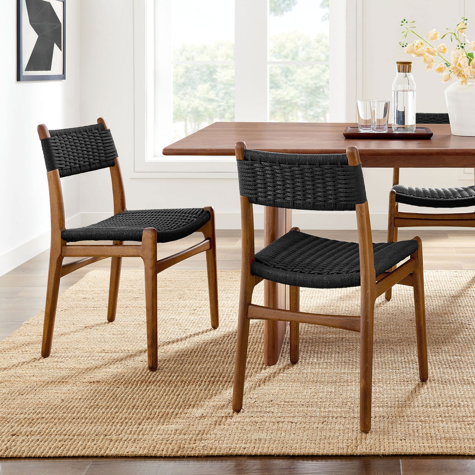 Set of two black rope and walnut dining chairs styled around a wood table in a sunlit room || EEI-7044-WAL-BLK || front_angle_multi_room