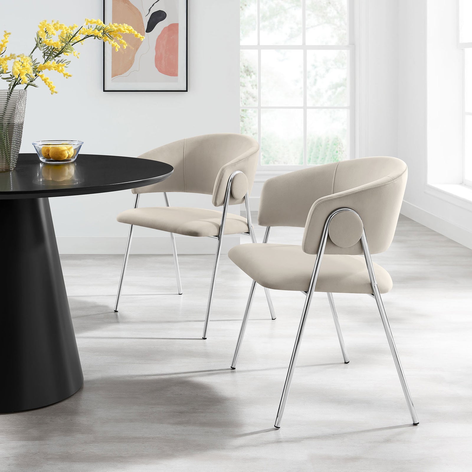 Pair of almond silver velvet dining chairs around a modern table for an inviting, contemporary dining setting. || EEI-7046-ALM-SLV || front_angle_multi_room