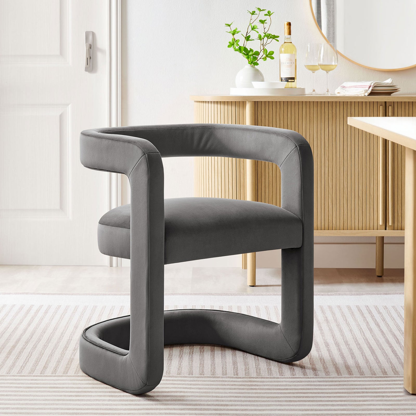 Storm gray barrel dining chair in a modern dining room, paired with a light wood table and decor. || EEI-7052-STG || front_angle_room