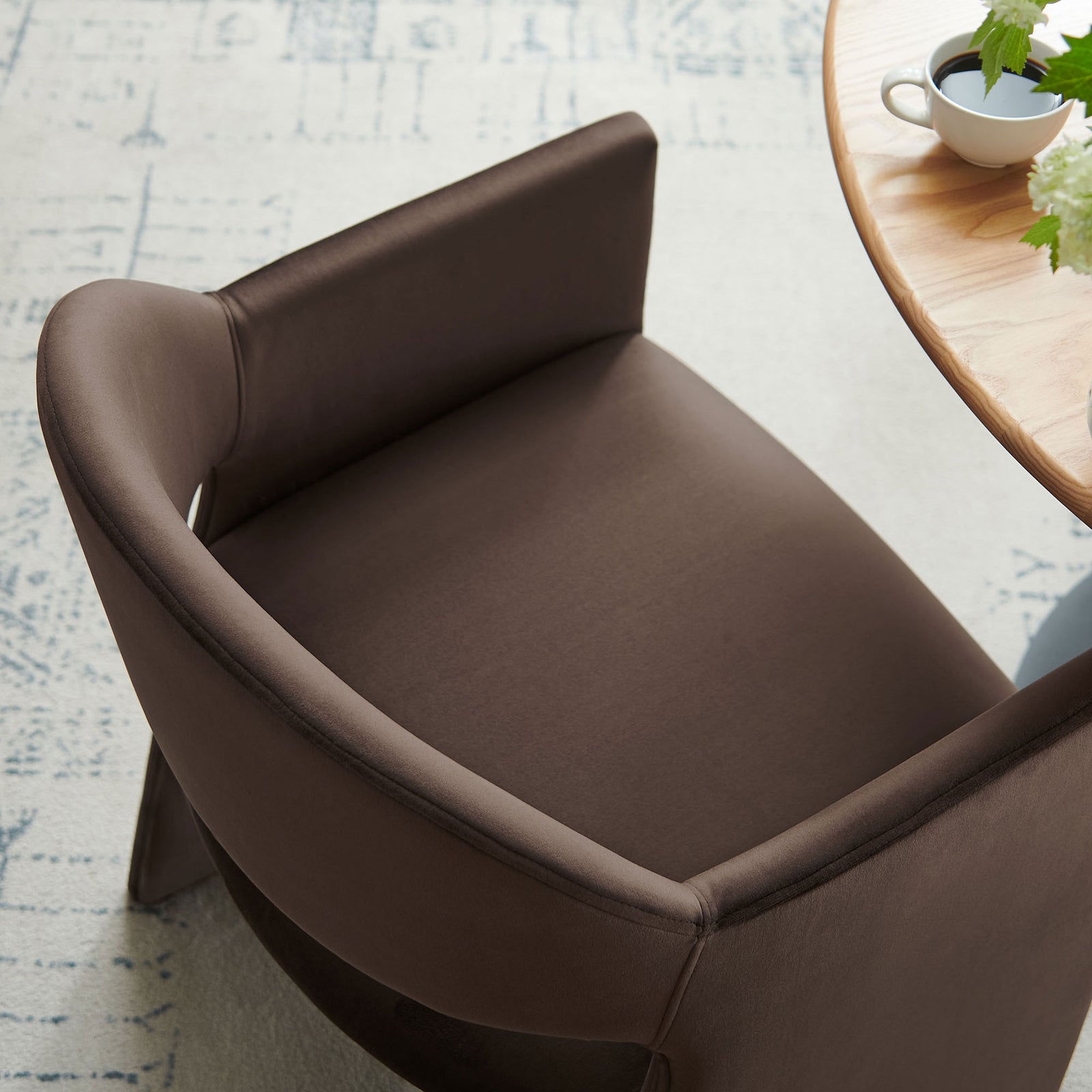 Talia chocolate velvet dining armchair tucked to a round table, showing plush seat and curved back in a cozy setting. || EEI-7081-CHB || detail_room