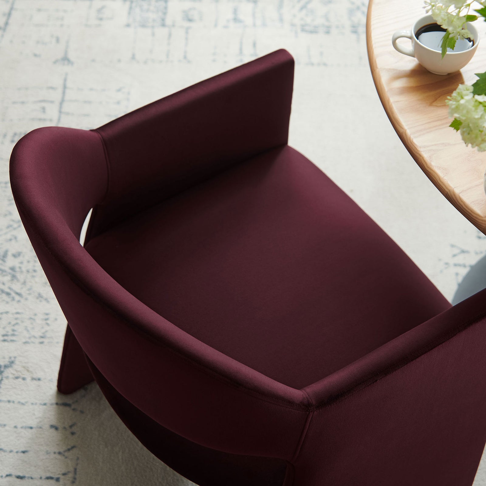 Lifestyle detail of mulberry velvet dining chair tucked at a round wood table in airy dining space || EEI-7081-MUL || detail_room